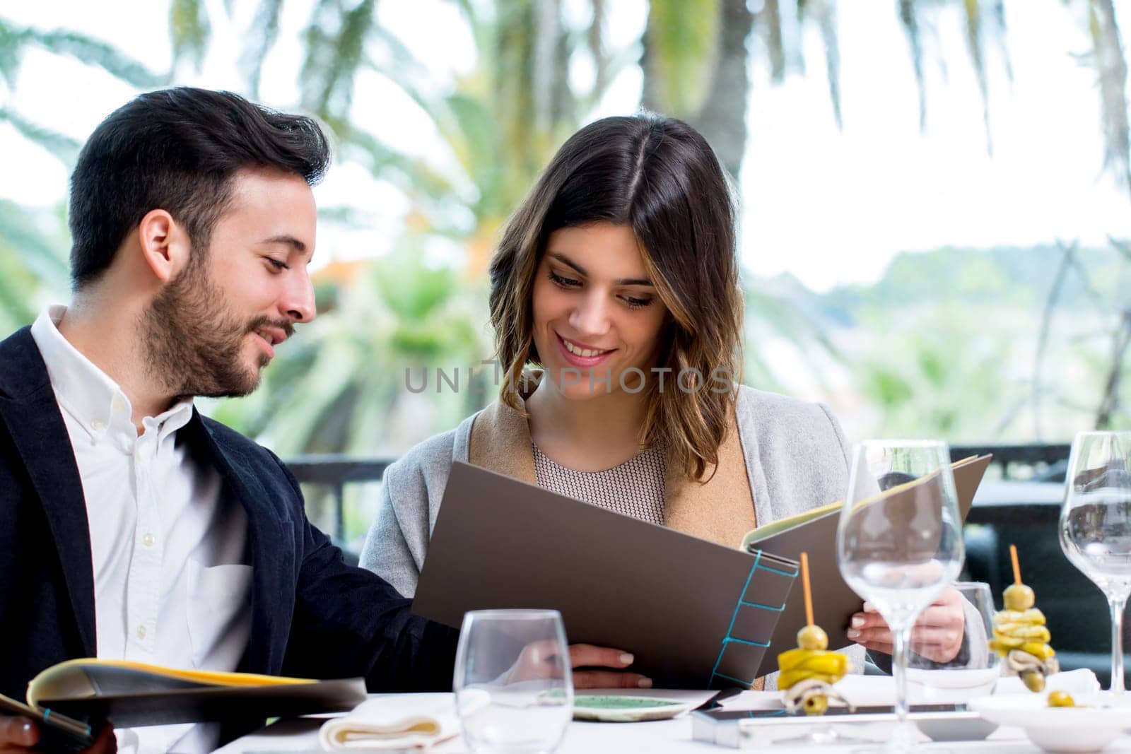 Close up portrait of young couple looking at restaurant menu in Hotel.