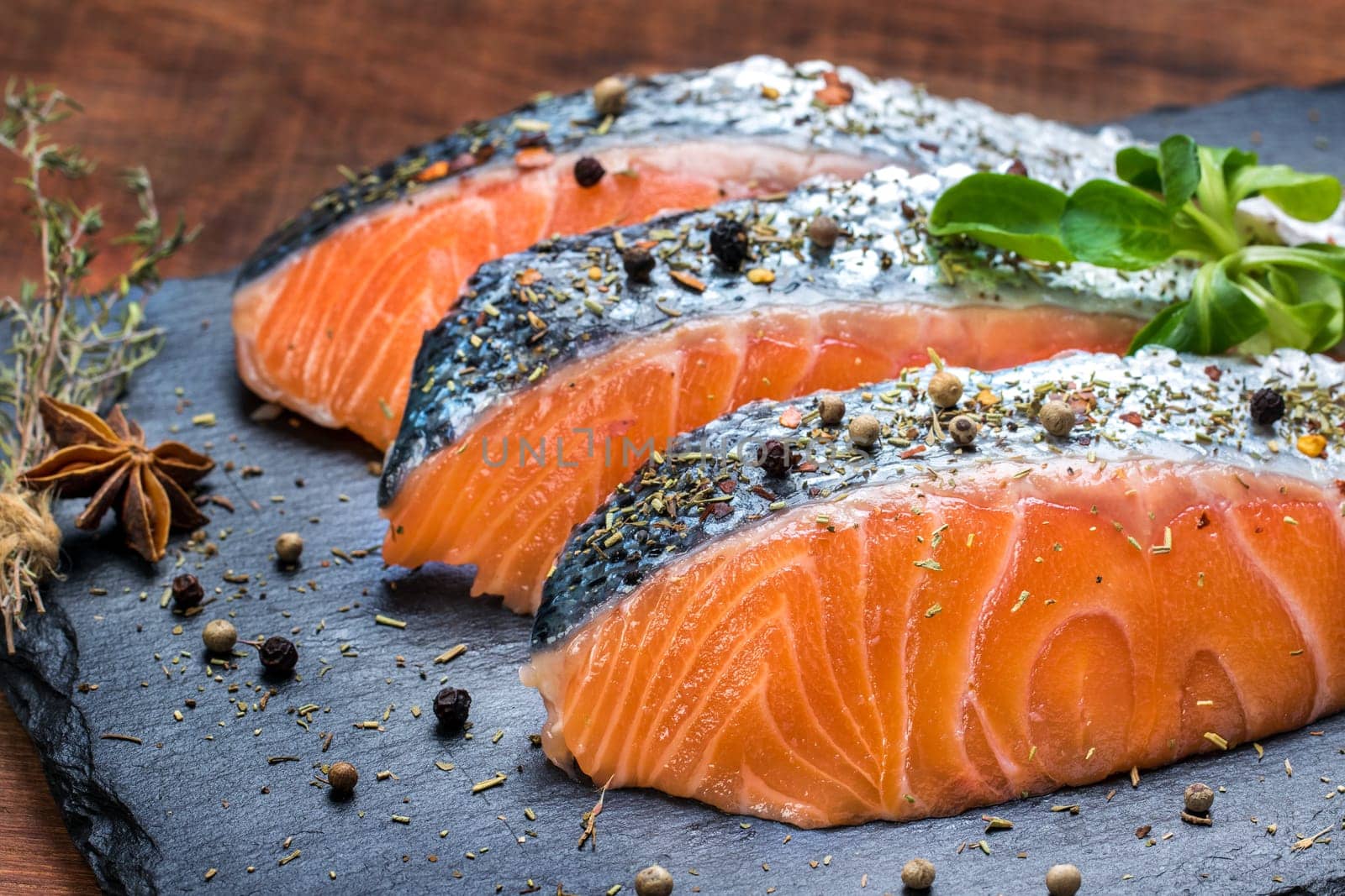 Macro close up of smoked salmon portions seasoned with aromatic herbs.