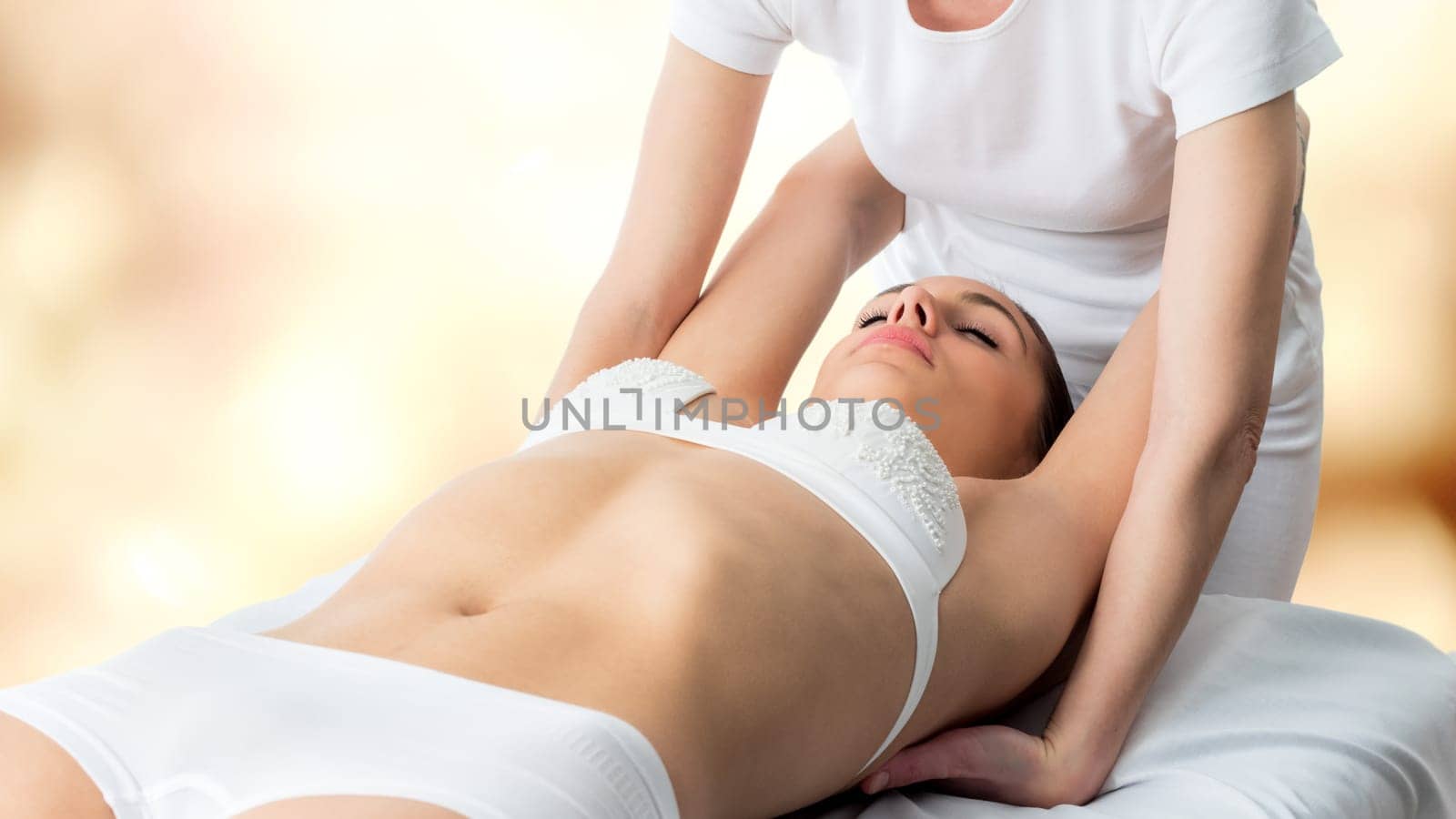 Close up of young woman receiving osteopathic massage. Therapist manipulating arms and shoulder blades.