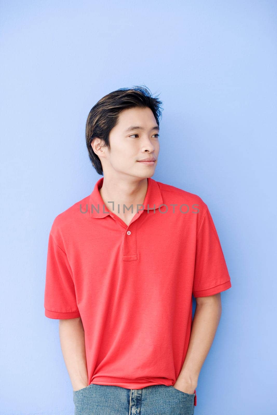 Young man leaning against a wall