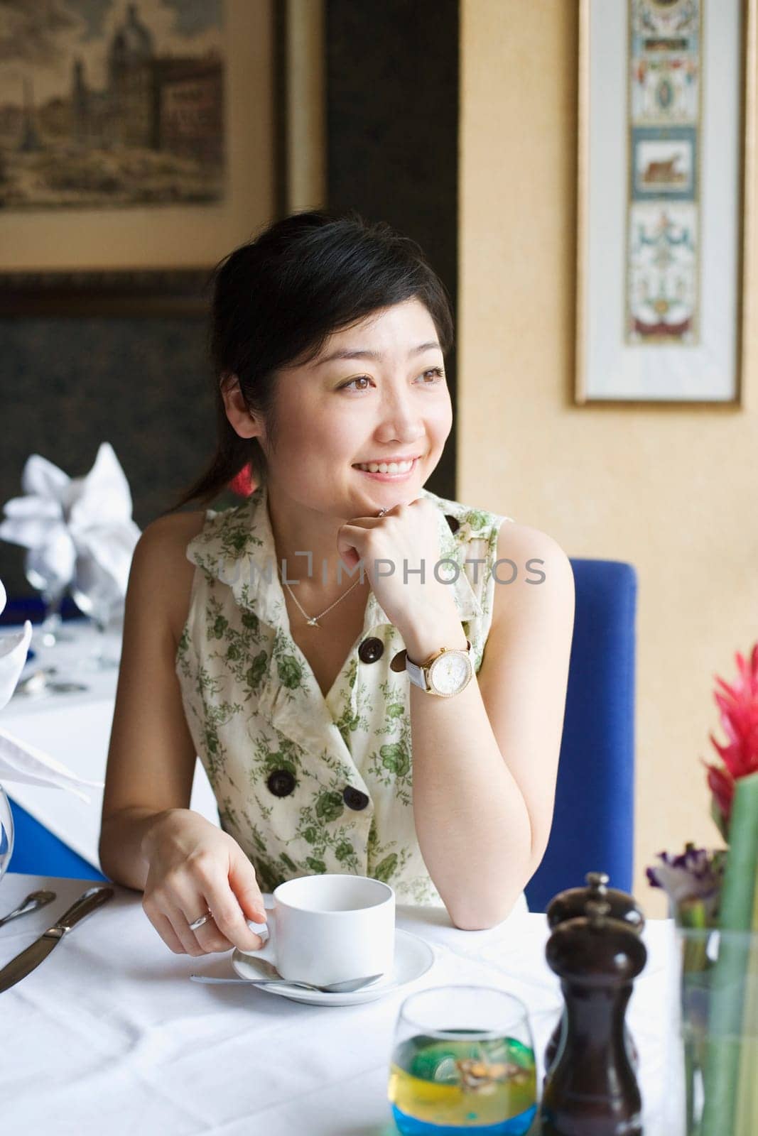 Young woman sitting in a restaurant with her hand on her chin