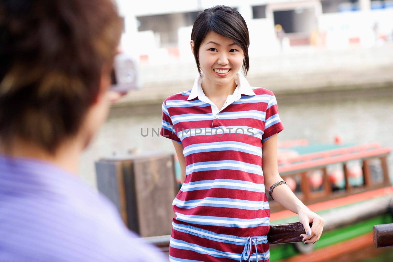 Rear view of a young man taking a picture of a young woman