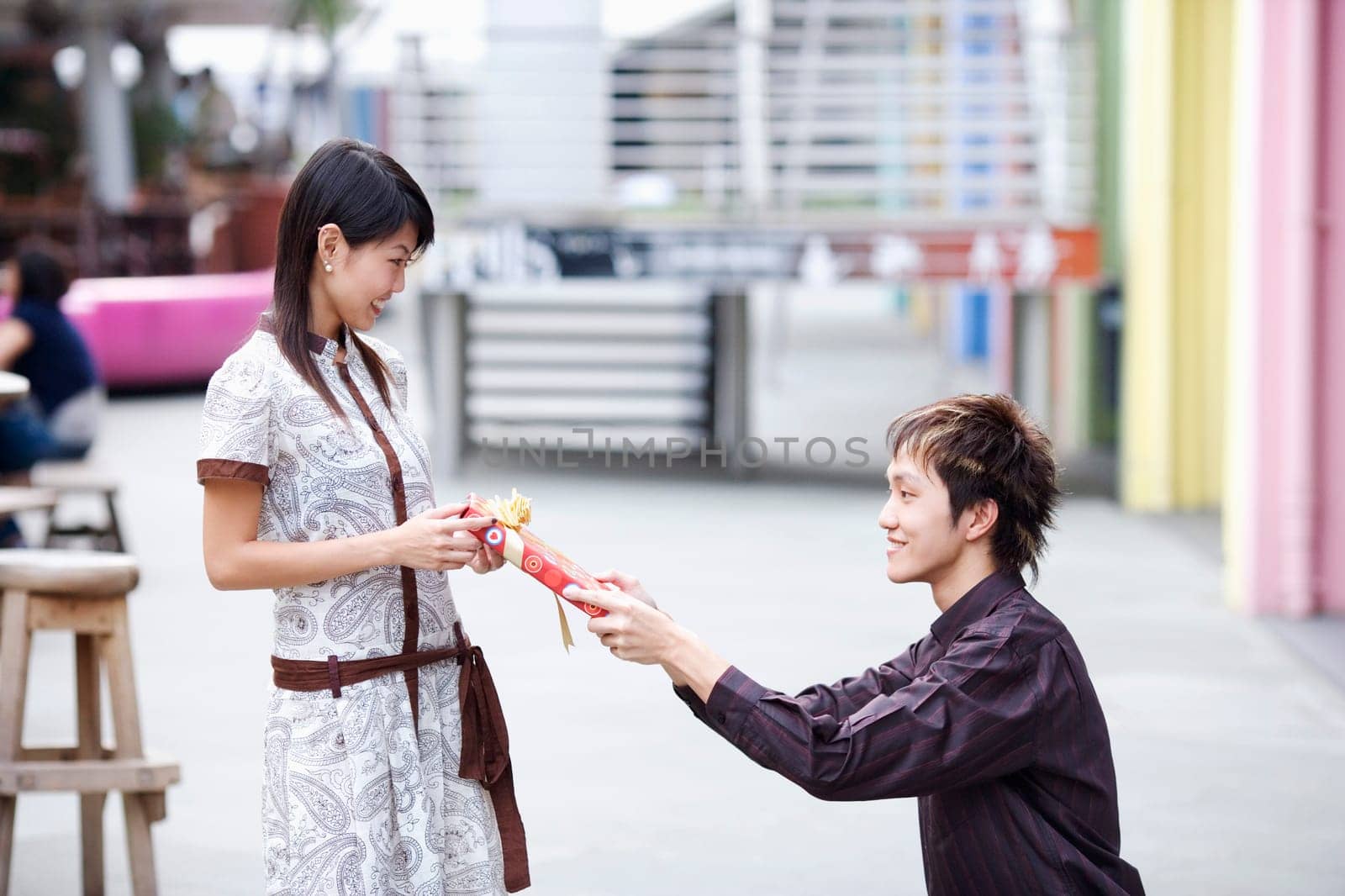 Side profile of a young man giving a gift to a young woman