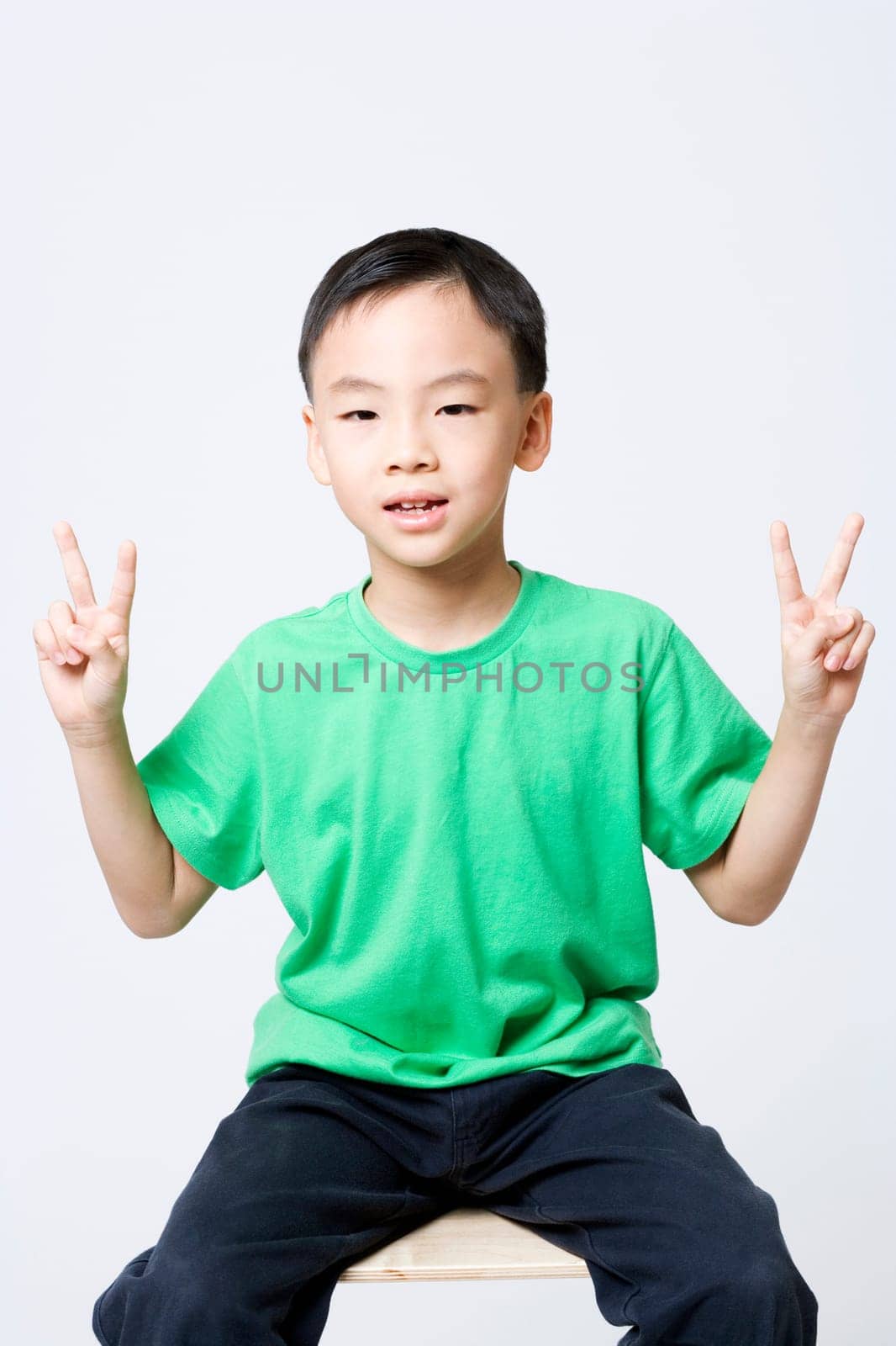 Portrait of a boy making a peace sign