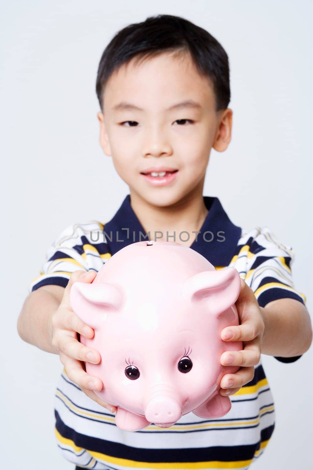 Portrait of a boy holding a piggy bank