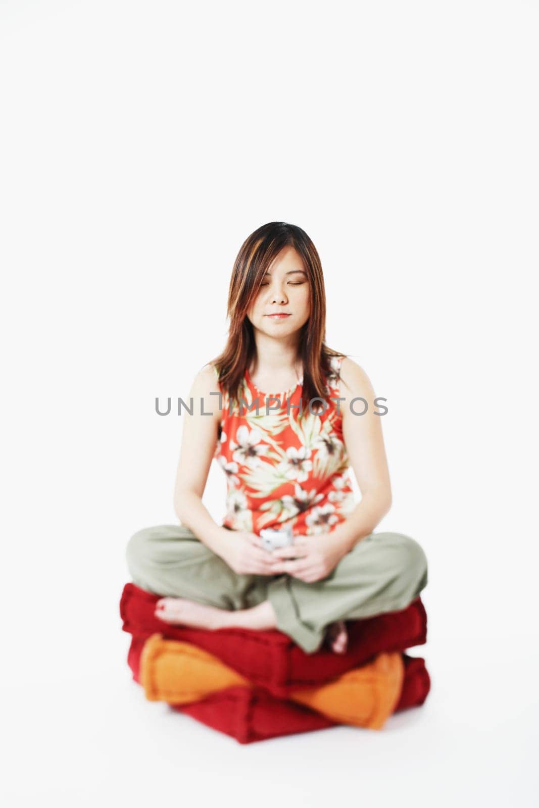 Mid adult woman sitting on cushions with her eyes closed