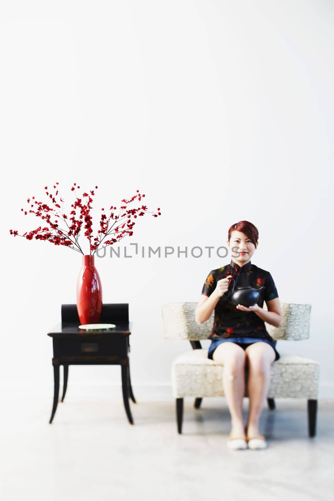 Portrait of a young woman holding a tea kettle
