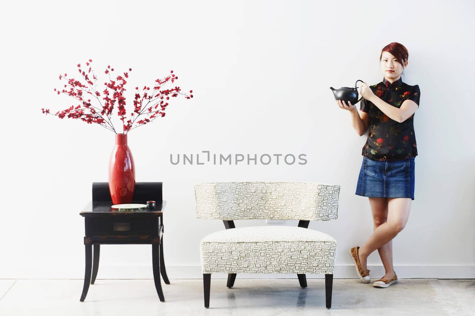 Portrait of a young woman standing with a teapot in her hand