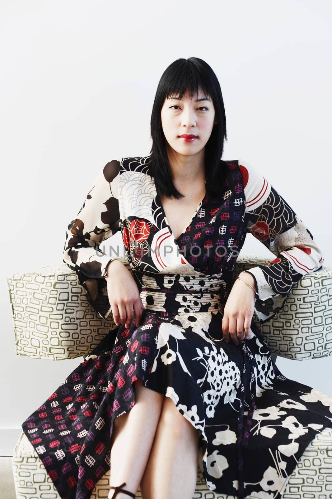 Portrait of a young woman sitting on an armchair
