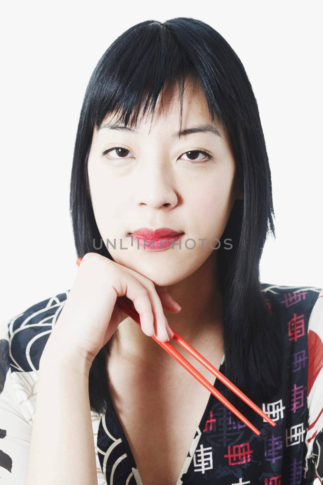 Portrait of a young woman holding chopsticks