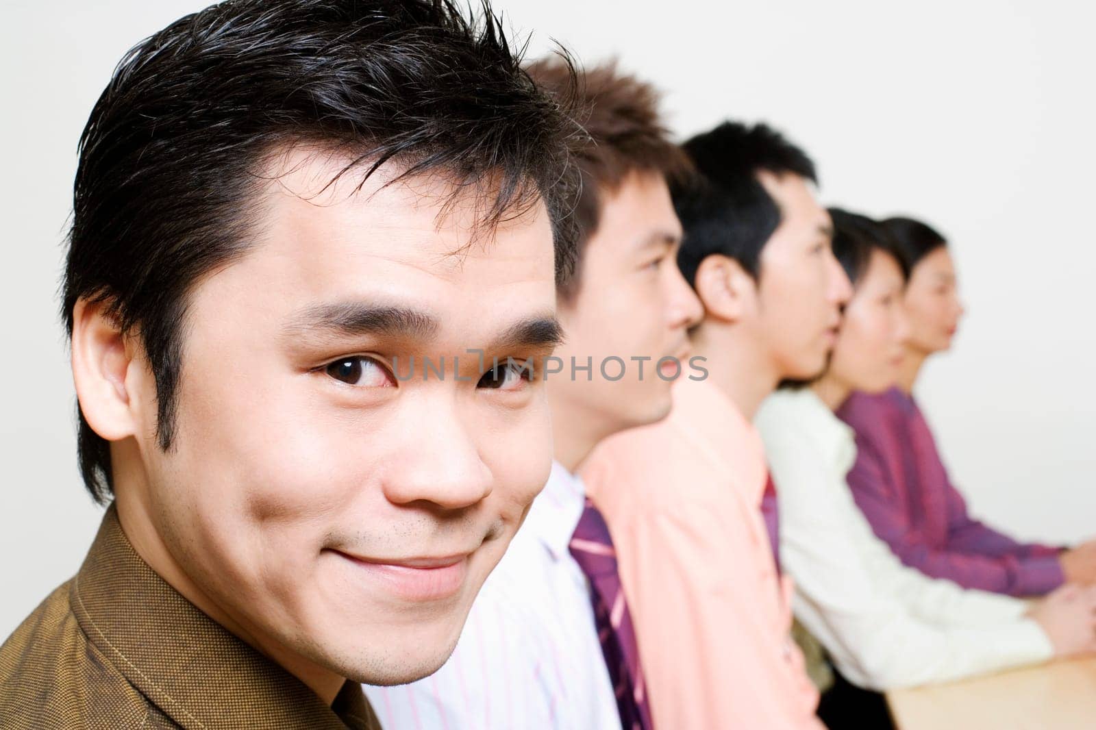 Three businessmen and two businesswomen sitting side by side