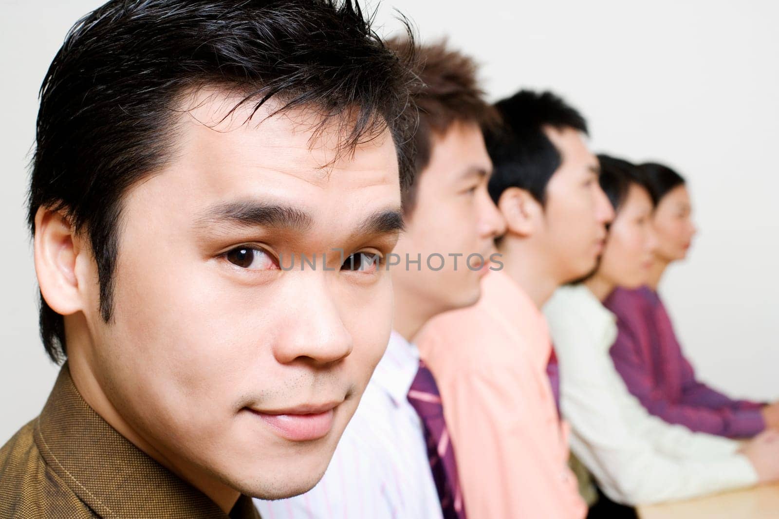 Three businessmen and two businesswomen sitting side by side