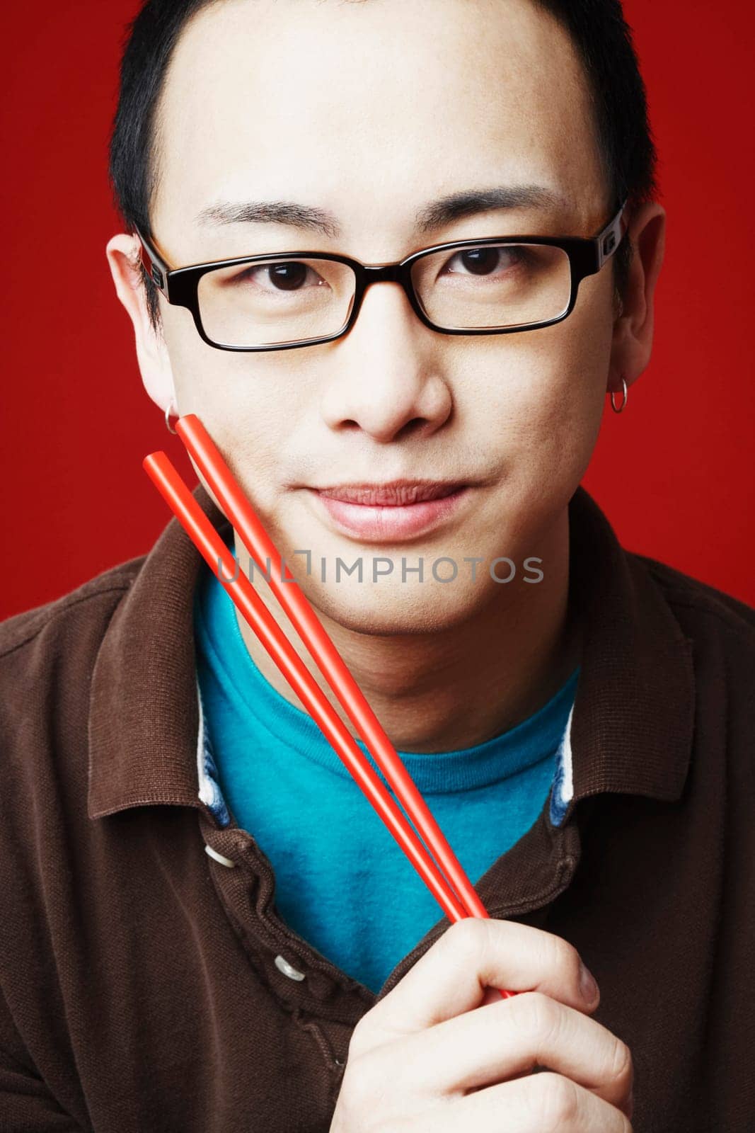 Portrait of a young man holding chopsticks
