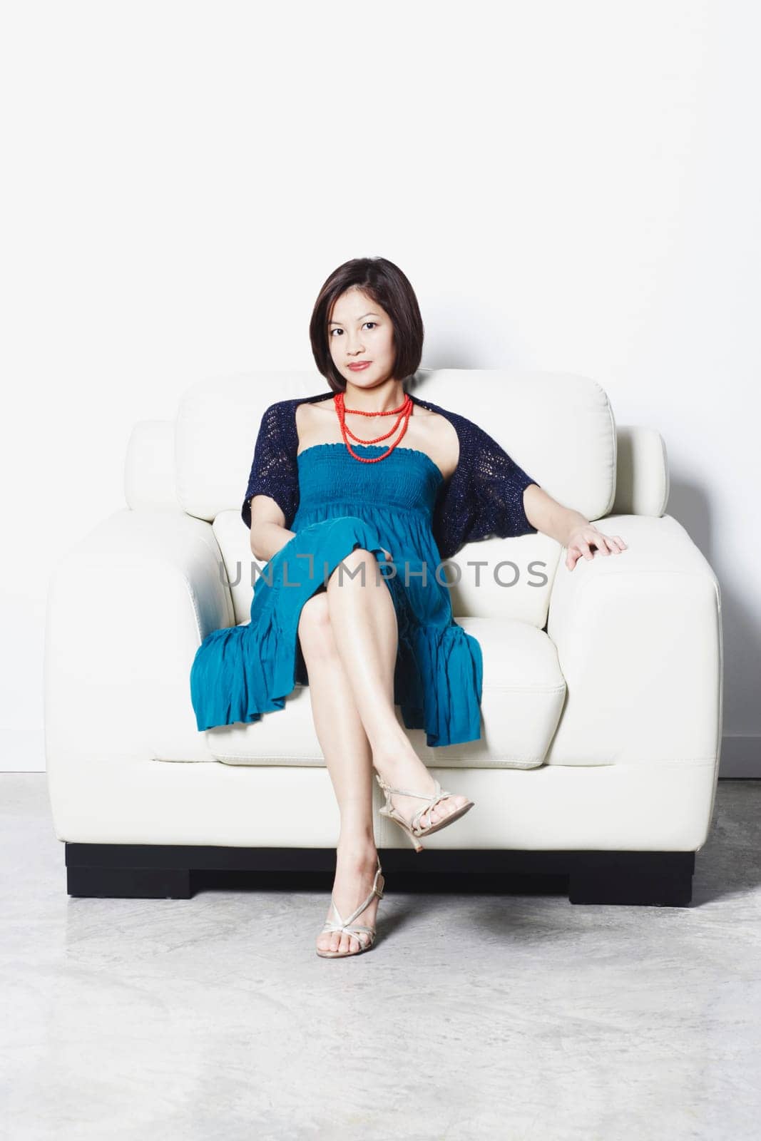 Portrait of a young woman sitting on an armchair