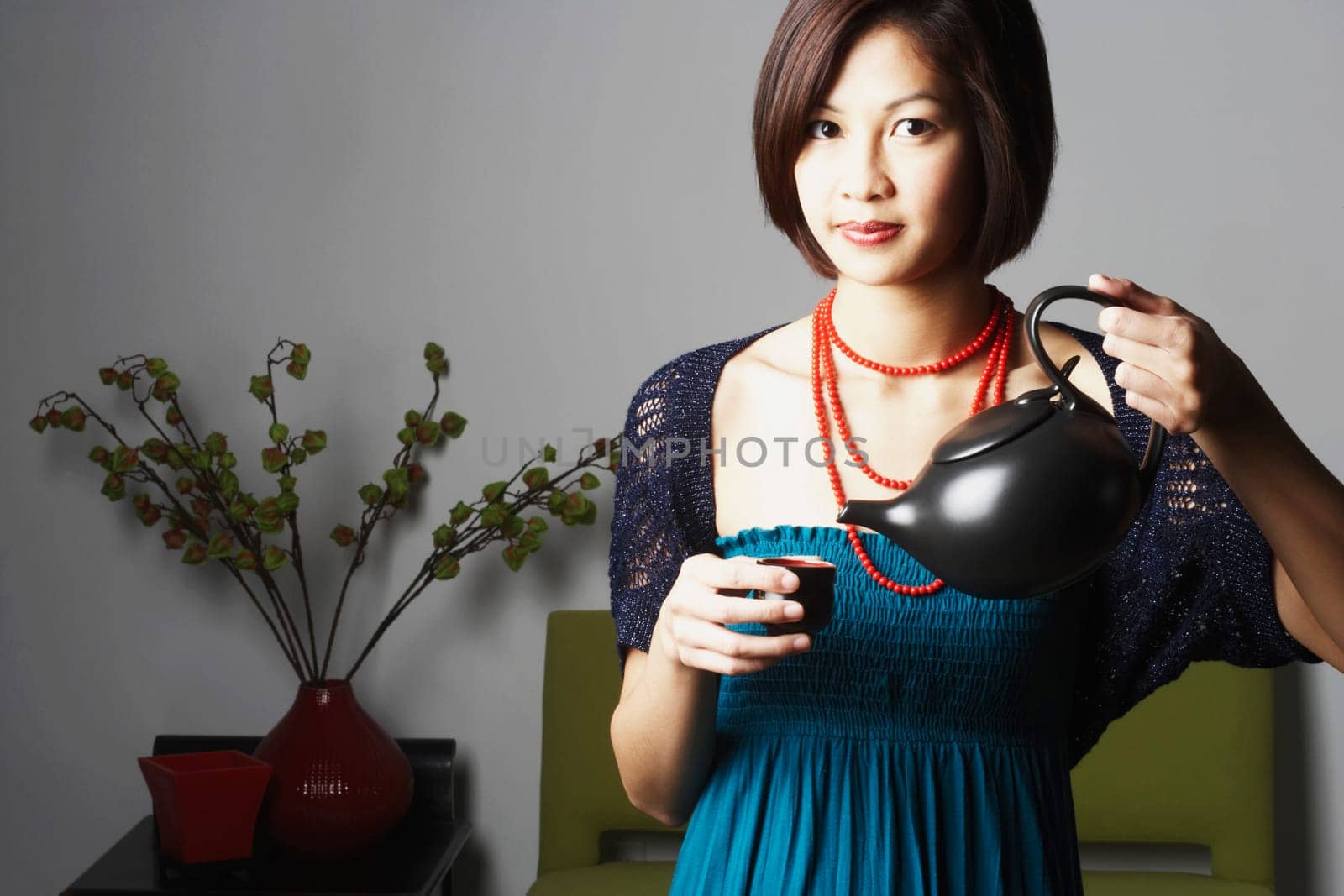 Portrait of a young woman pouring tea into a tea cup