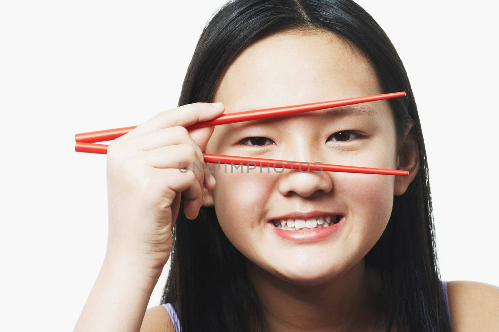 Portrait of a teenage girl looking through chopsticks