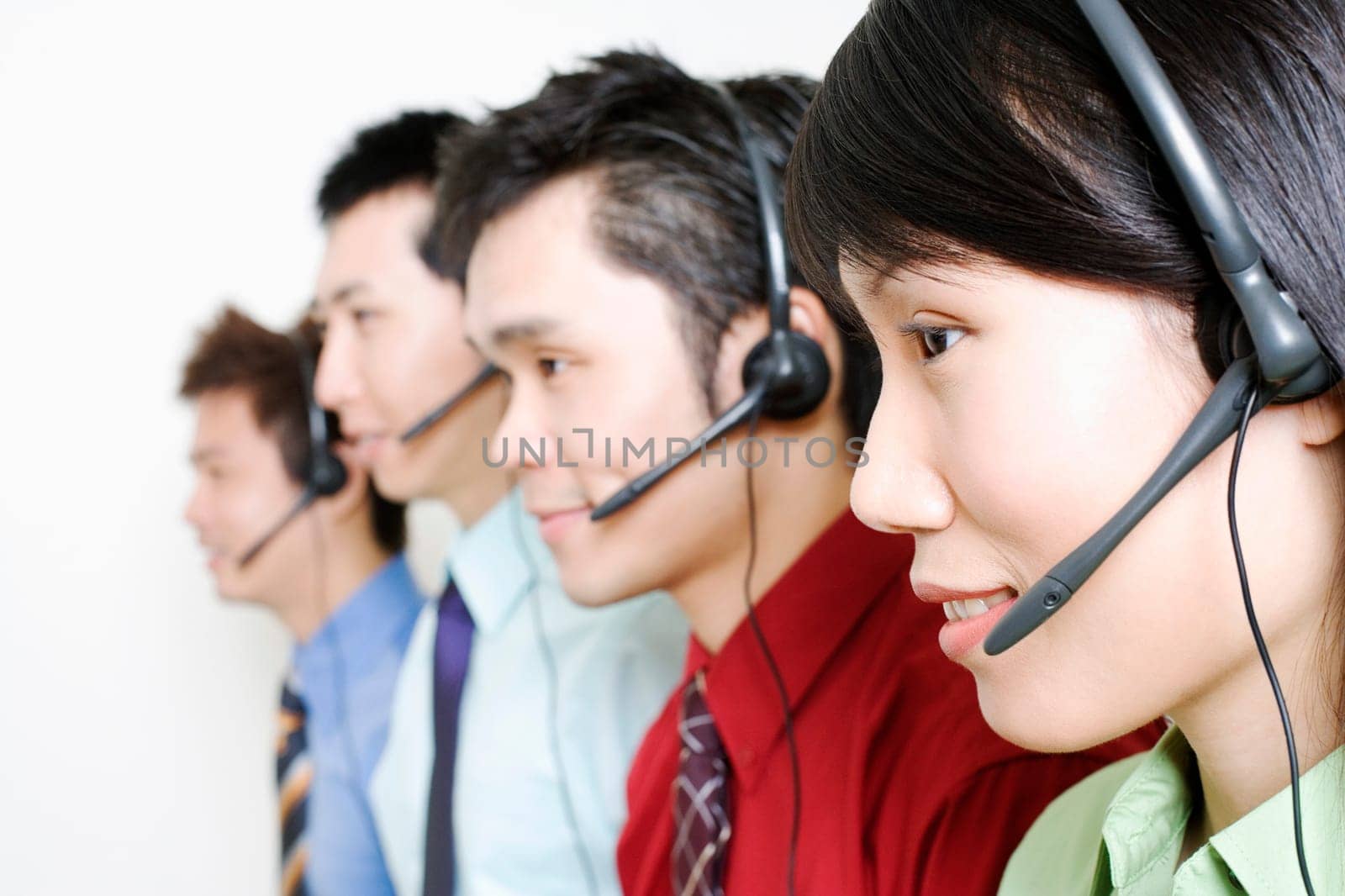 Four customer service representatives talking on headsets