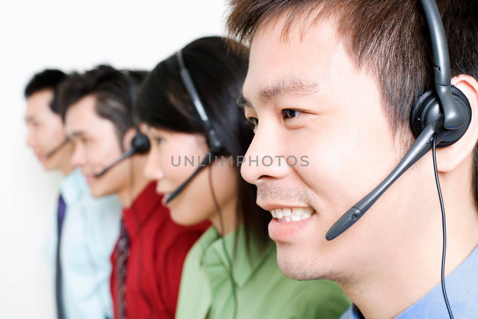Four customer service representatives talking on headsets