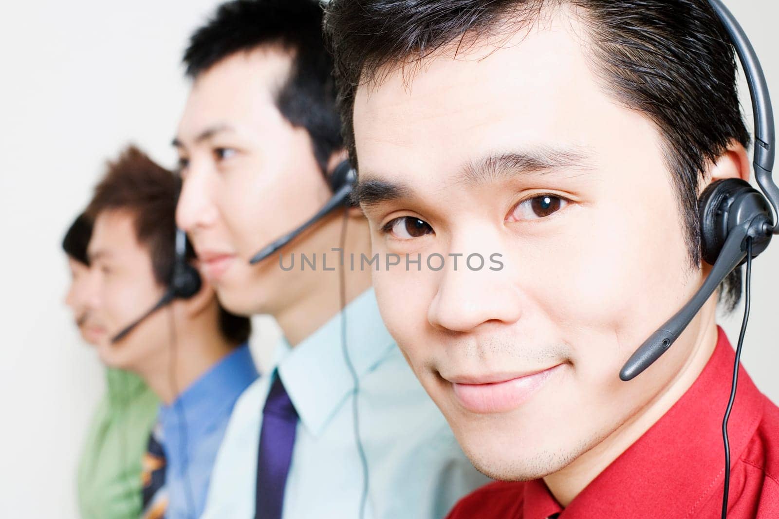 Four customer service representatives talking on headsets