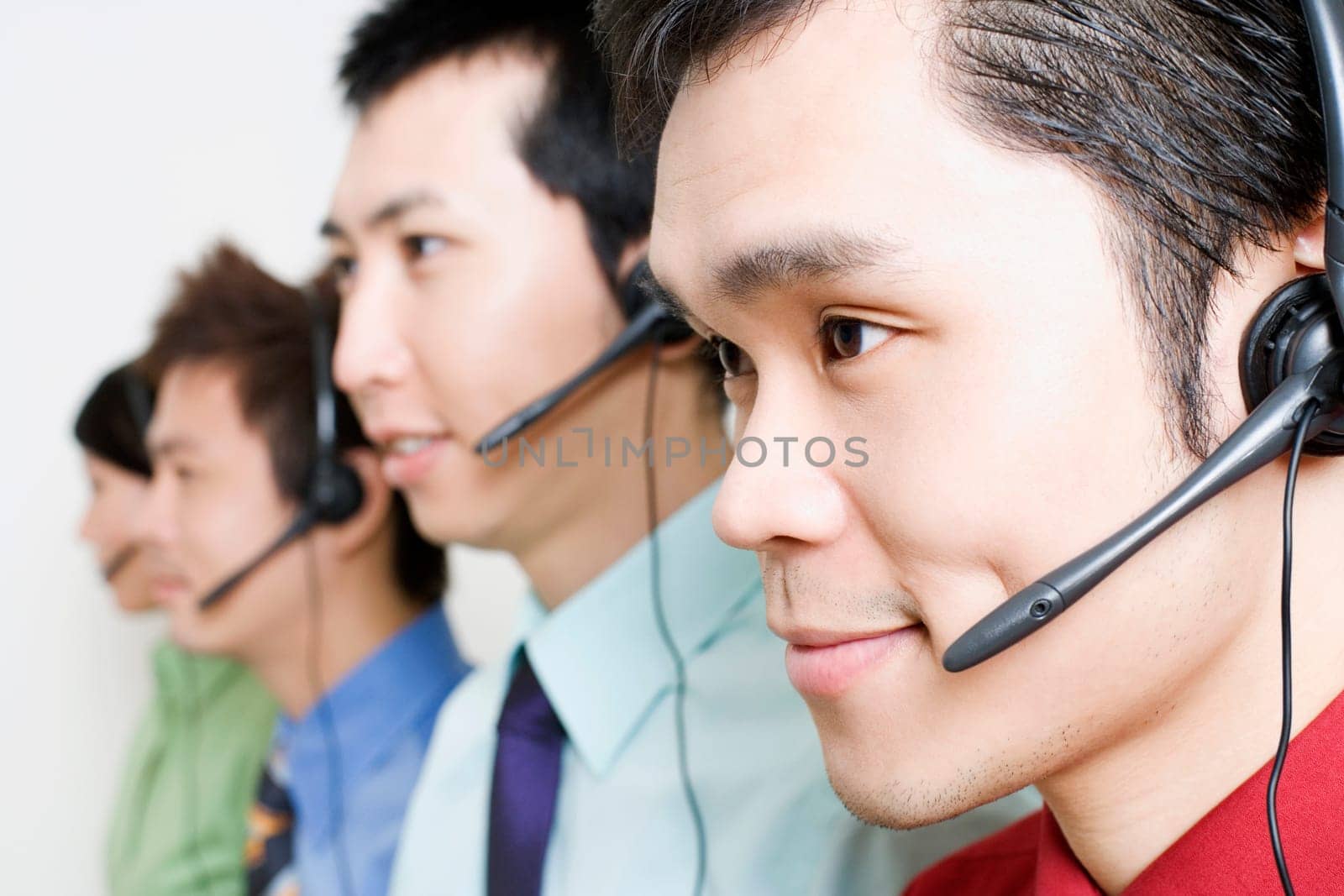 Four customer service representatives talking on headsets