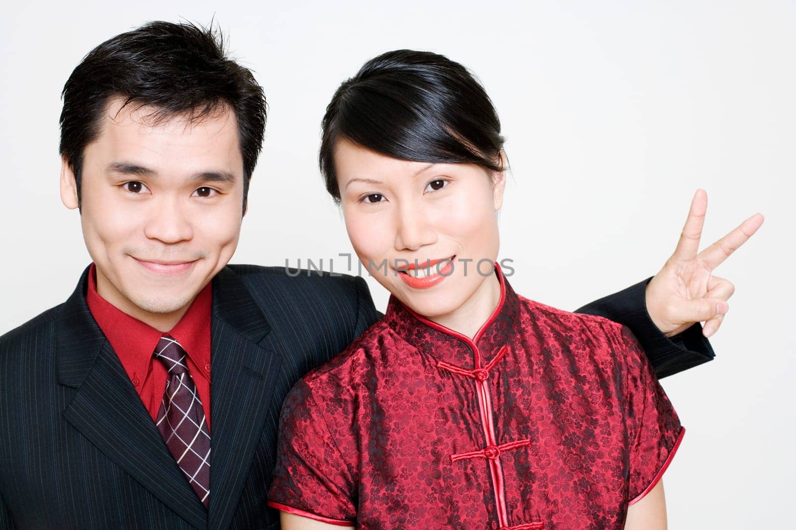 Portrait of a young woman smiling and a mid adult man making a peace sign