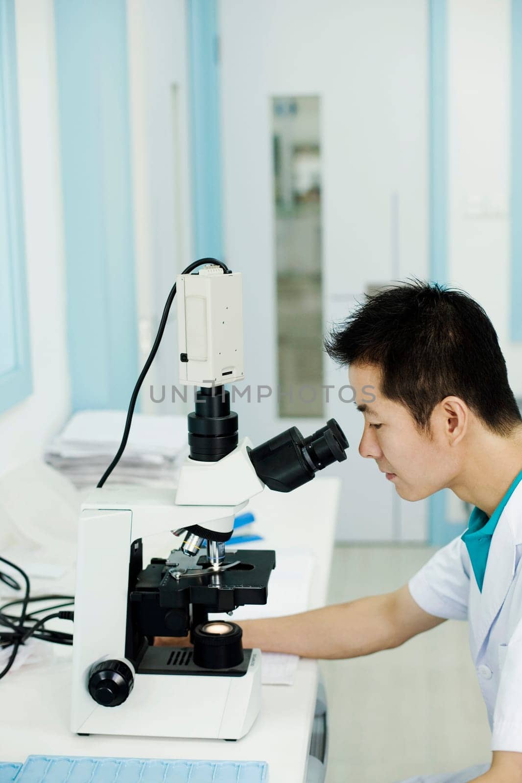 Side profile of a doctor looking into a microscope