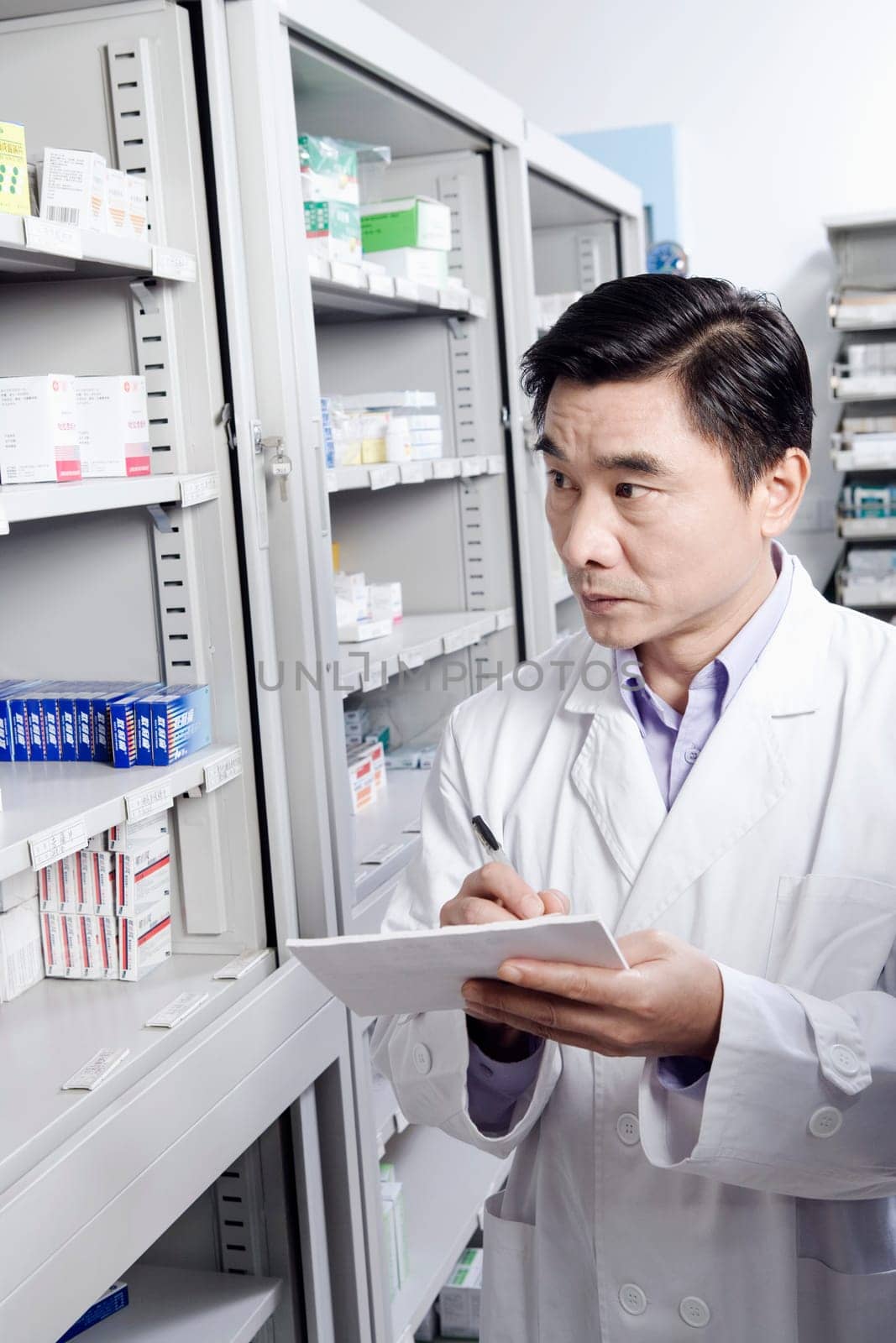 Male pharmacist writing in a store room
