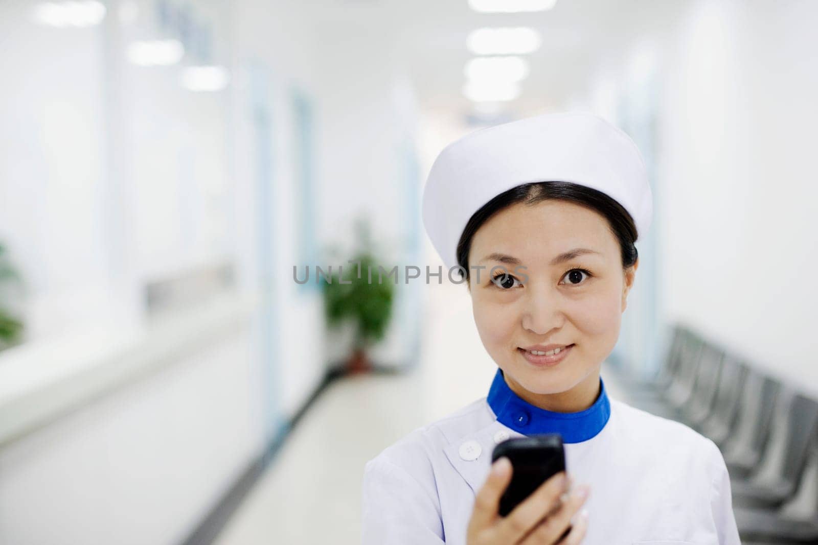 Portrait of a female nurse operating a mobile phone