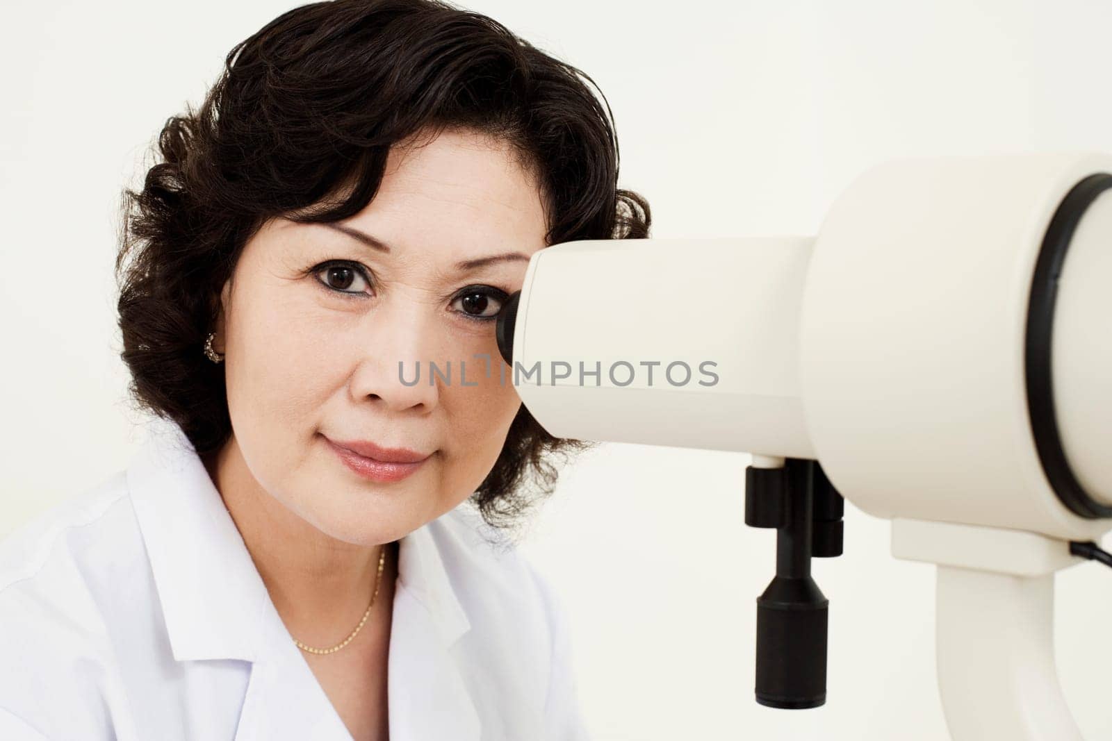 Portrait of an optometrist in front of an ophthalmoscope