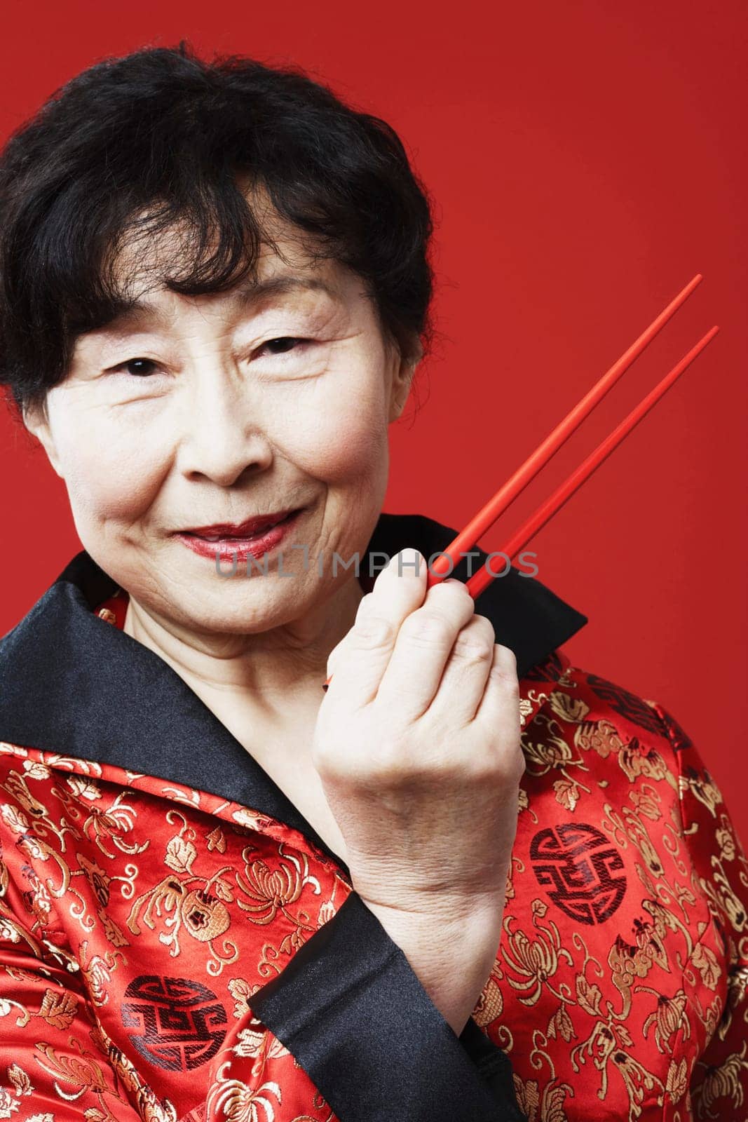 Portrait of a mature woman holding chopsticks
