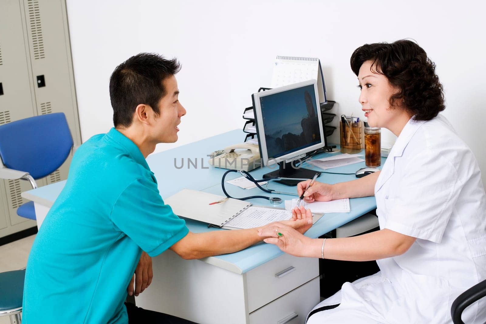 Side profile of a female doctor taking a patientŽs pulse