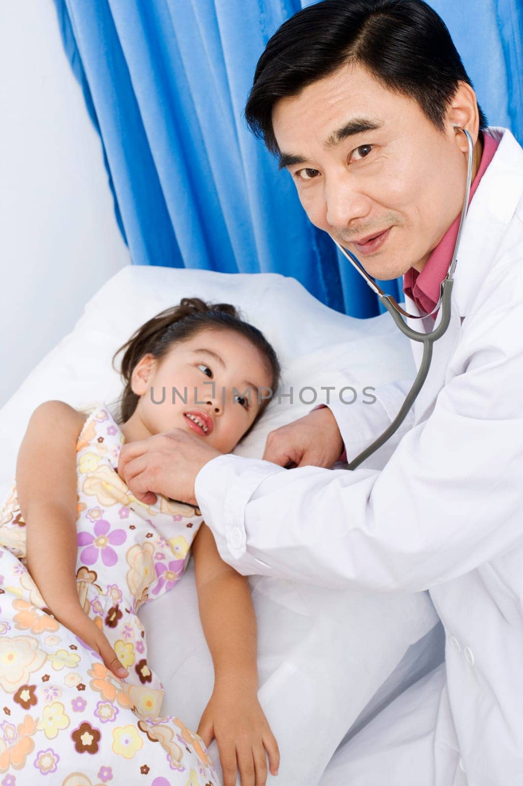 Portrait of a male doctor examining a girl