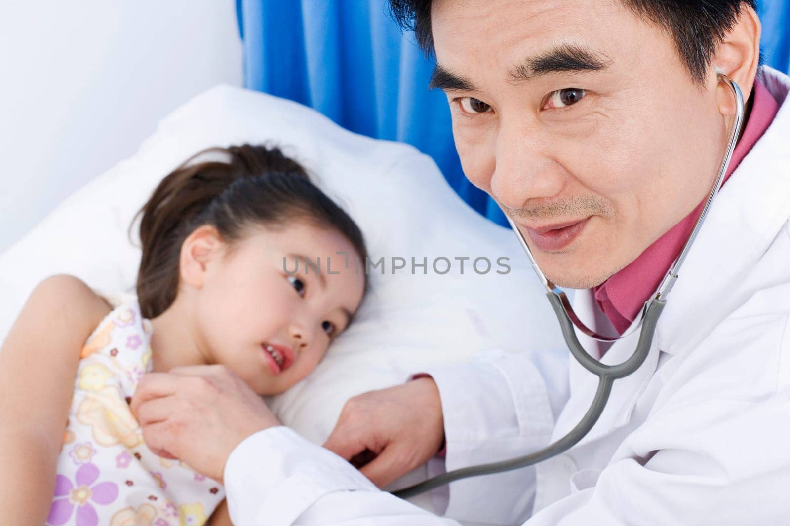 Portrait of a male doctor examining a girl