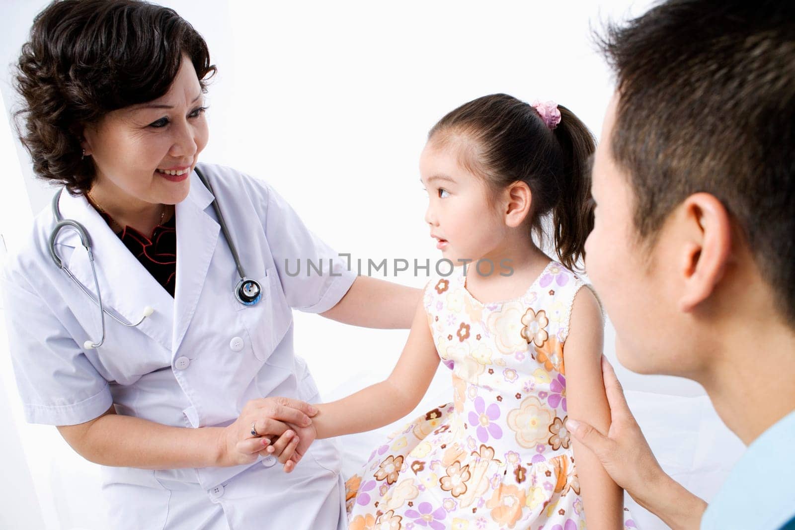 Close-up of a female doctor examining a girl and smiling