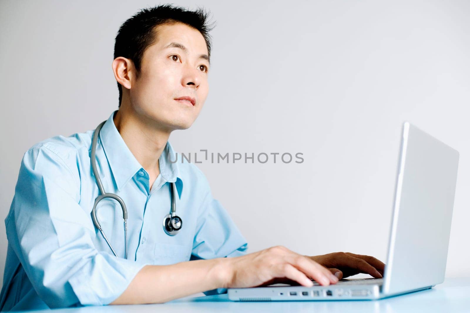 Close-up of a doctor operating a laptop