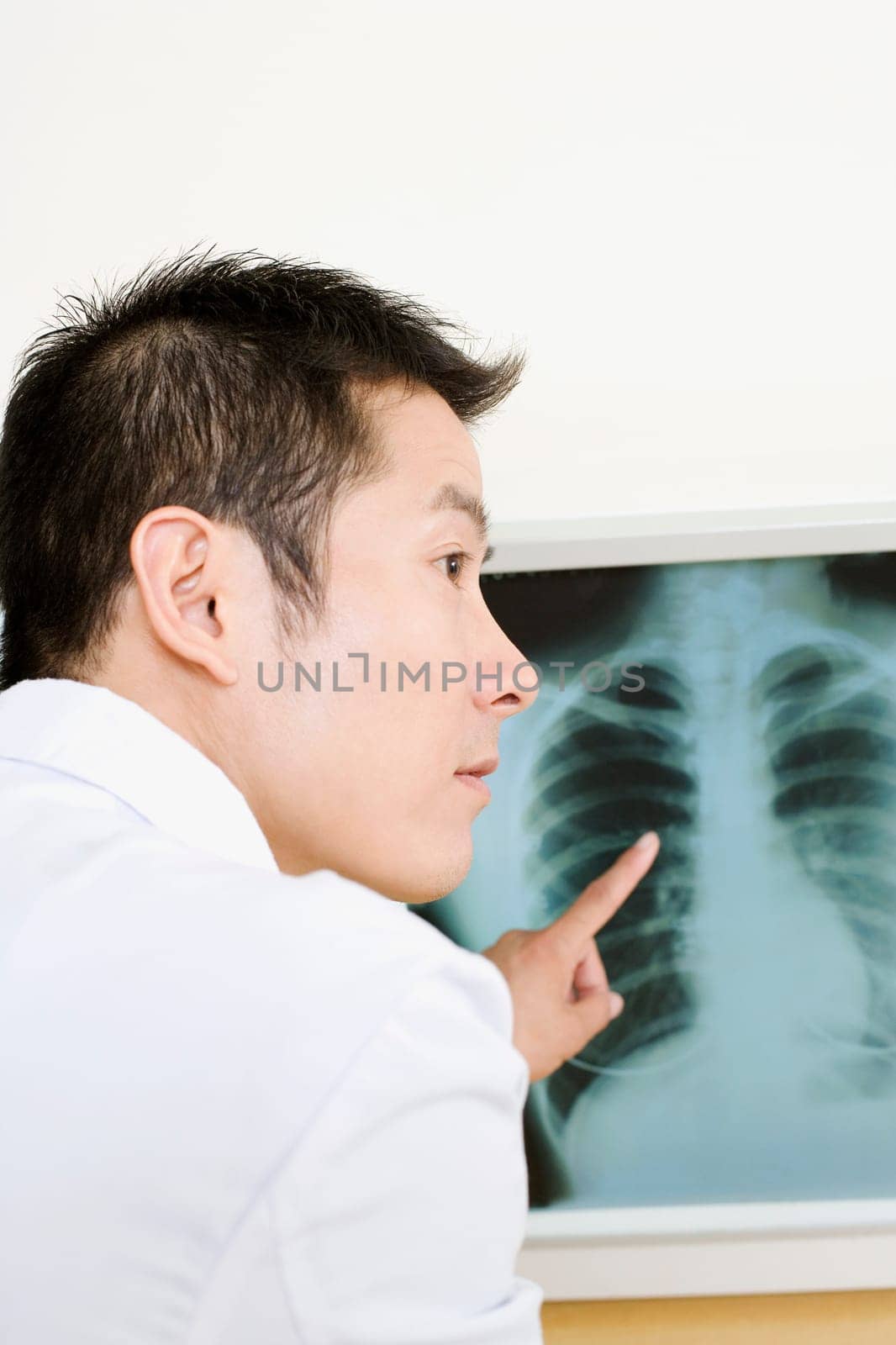 Rear view of a male doctor pointing to an X-Ray