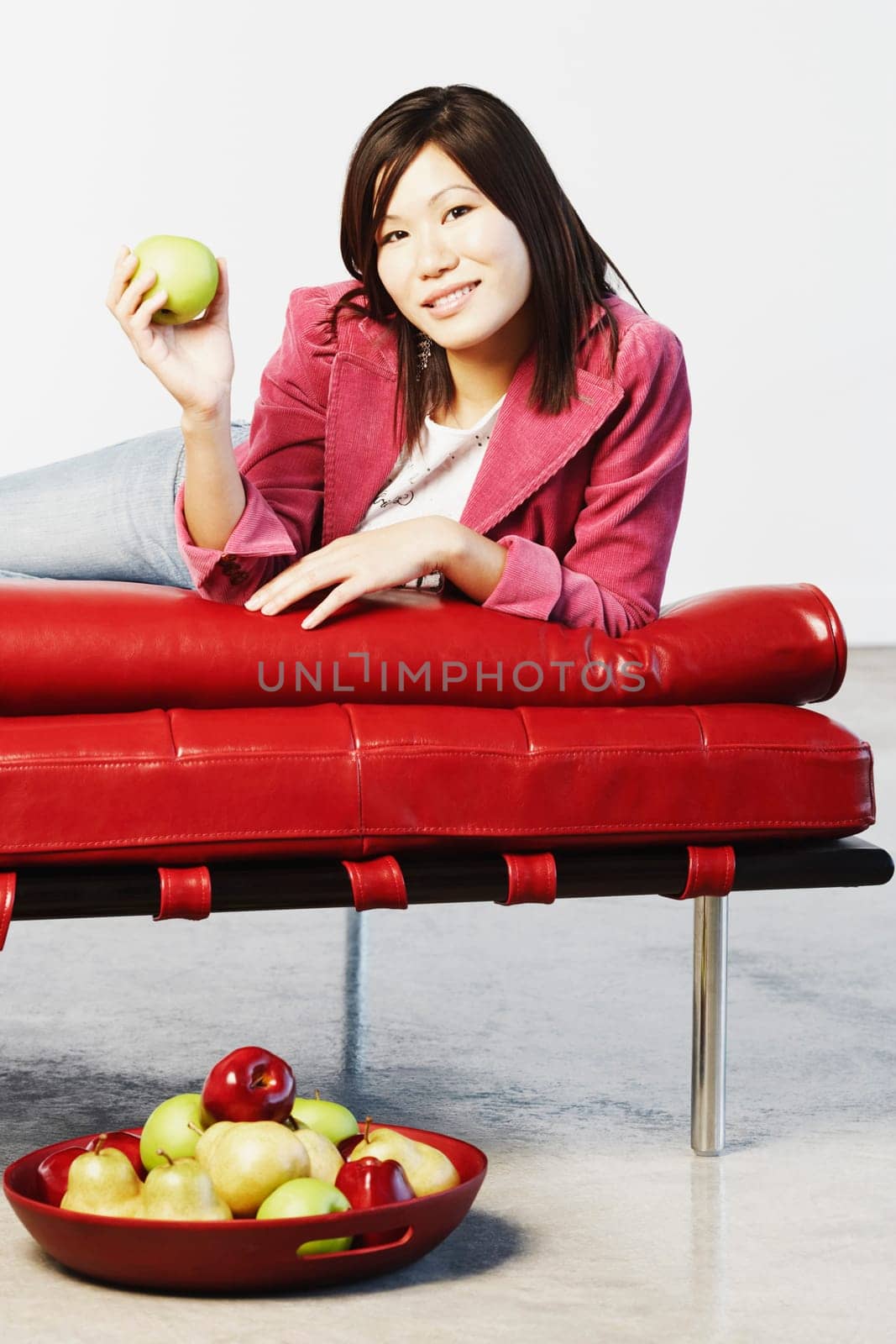 Portrait of a young woman holding a green apple