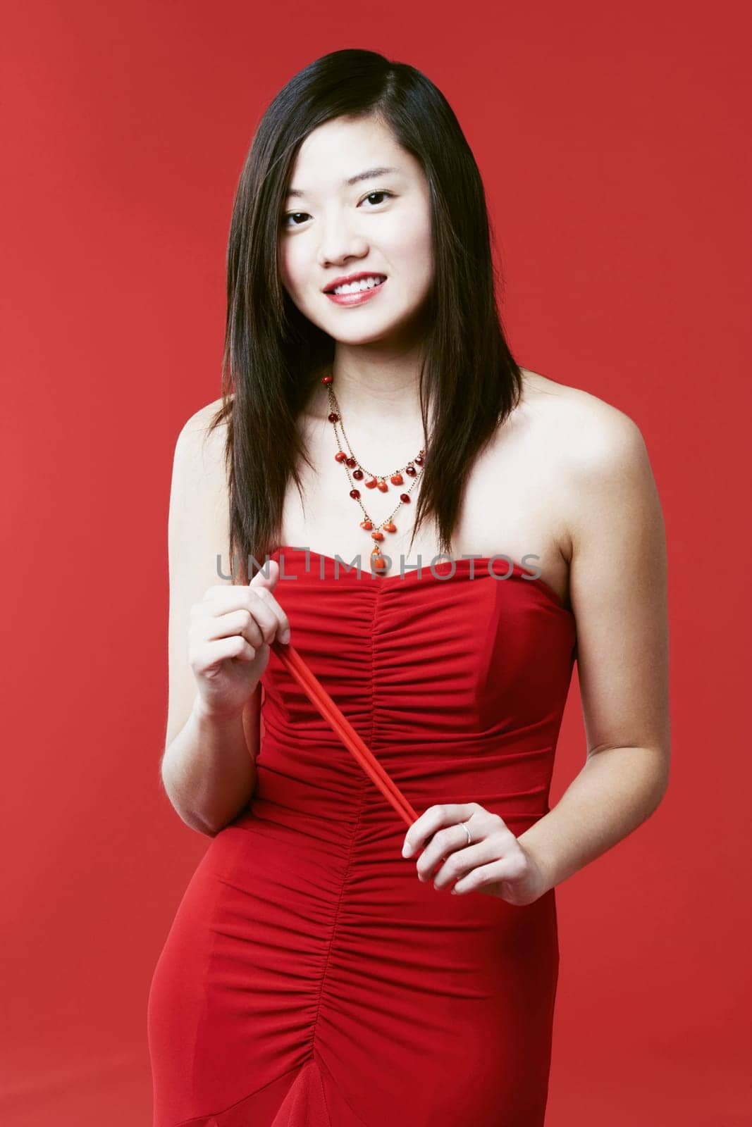 Portrait of a young woman holding chopsticks