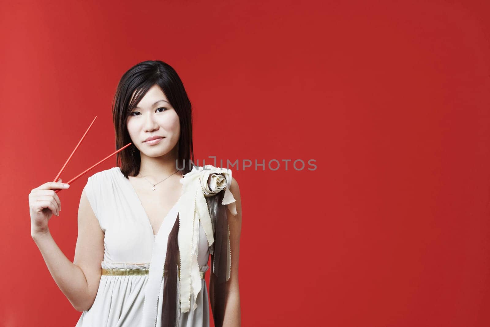 Portrait of a young woman holding chopsticks