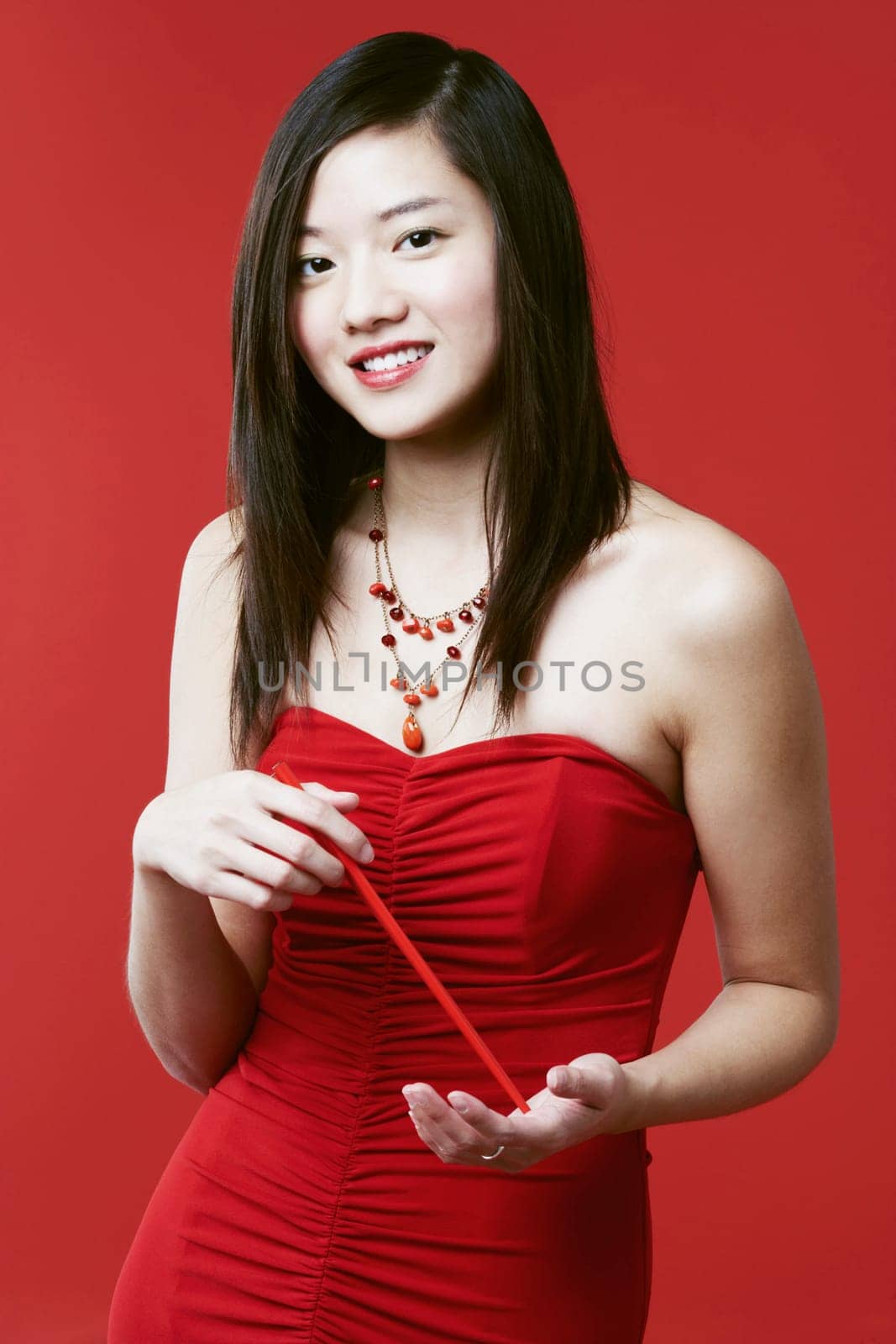 Portrait of a young woman holding chopsticks