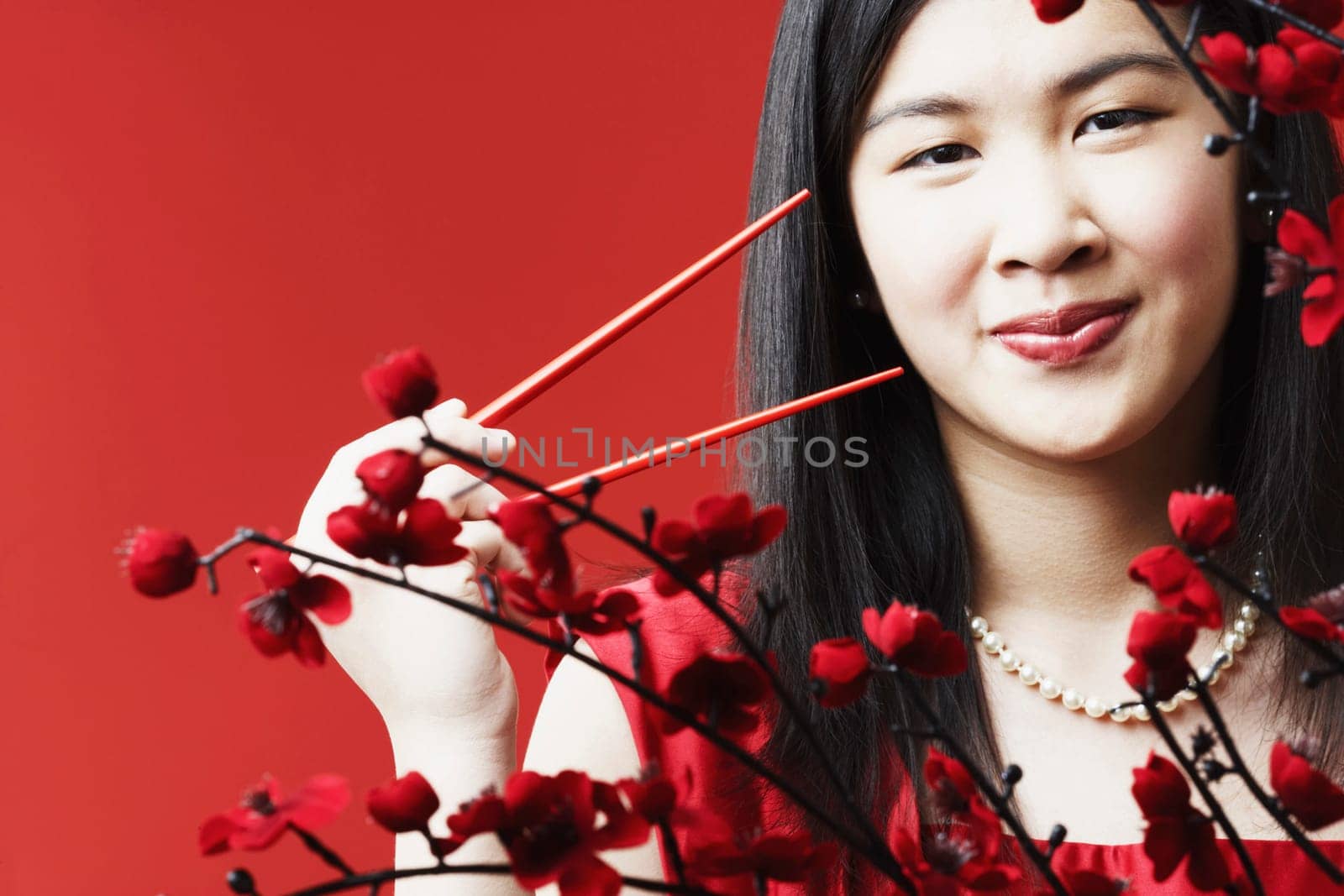 Portrait of a young woman holding chopsticks