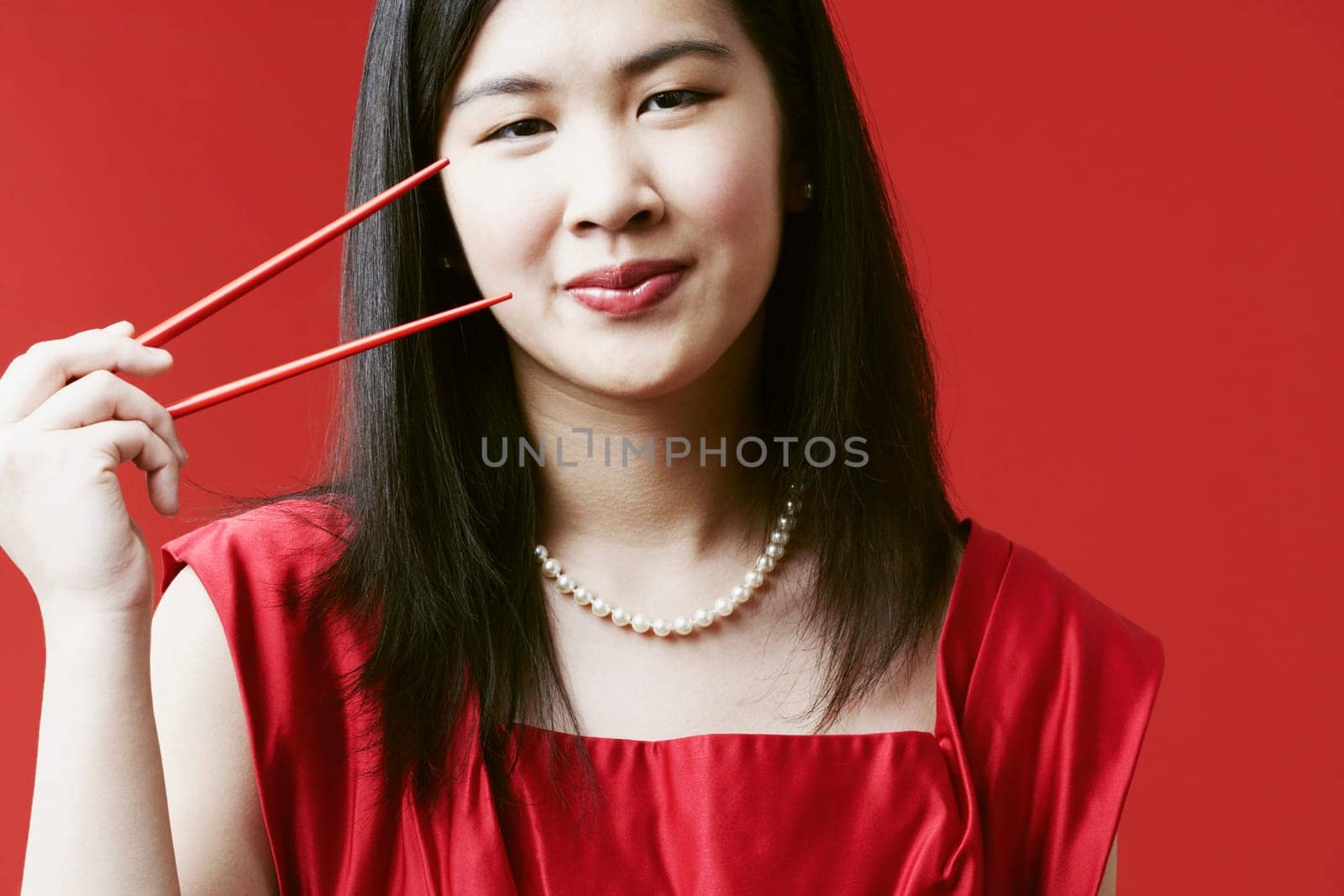 Portrait of a young woman holding chopsticks