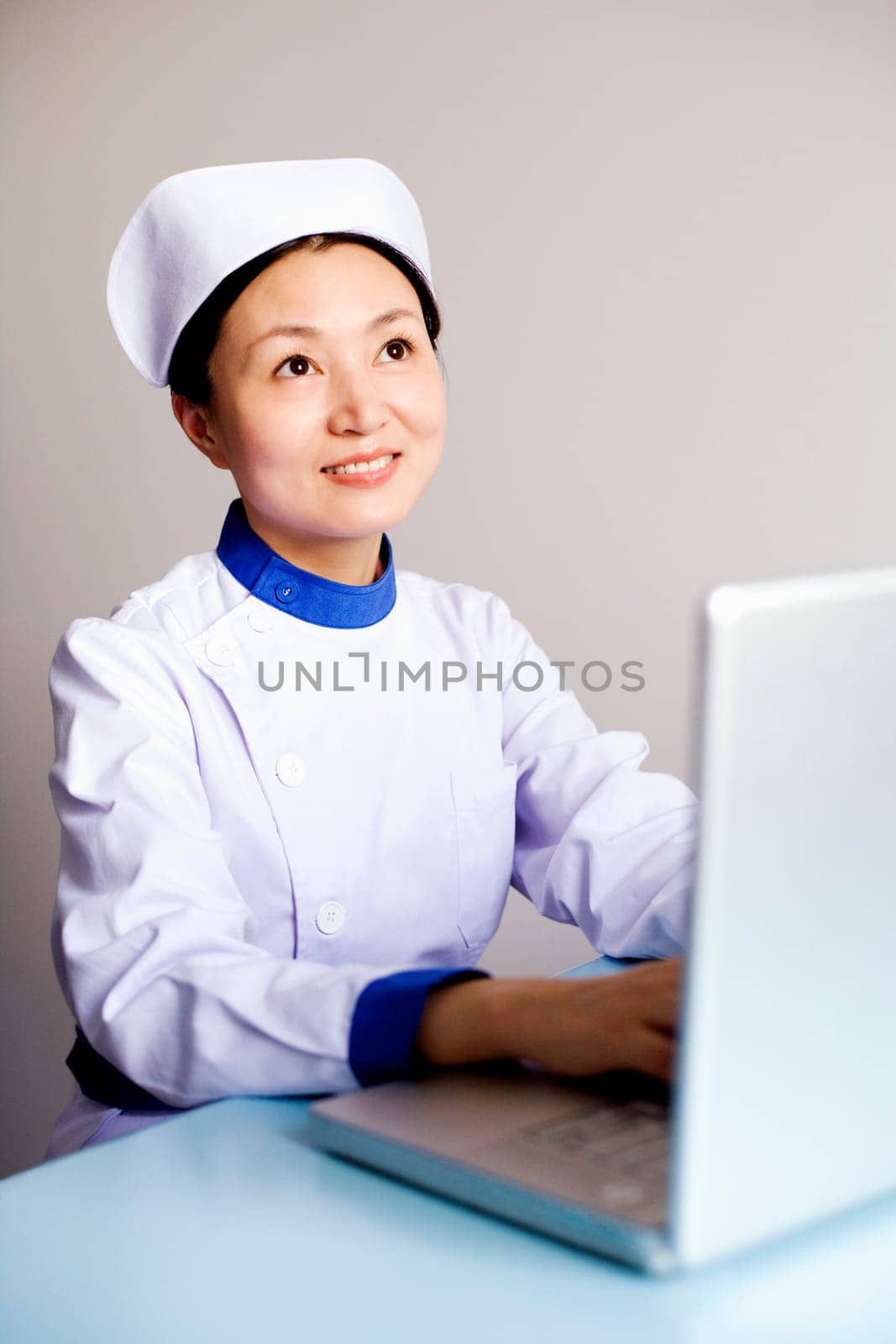 Close-up of a female nurse working on a laptop