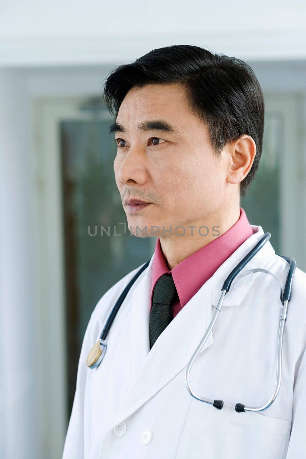 Close-up of a male doctor standing and looking away