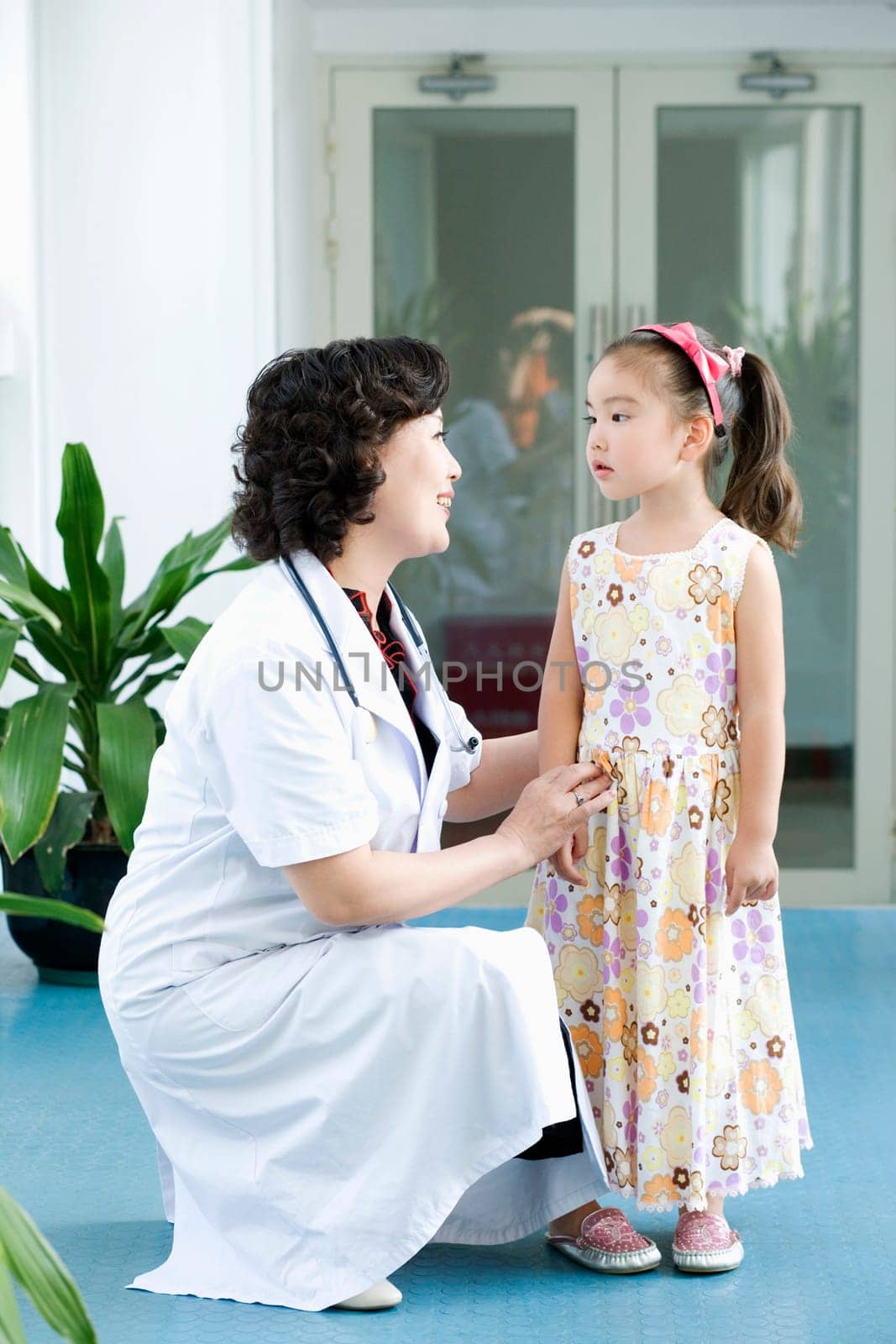 Side profile of a female doctor smiling with a girl standing beside her