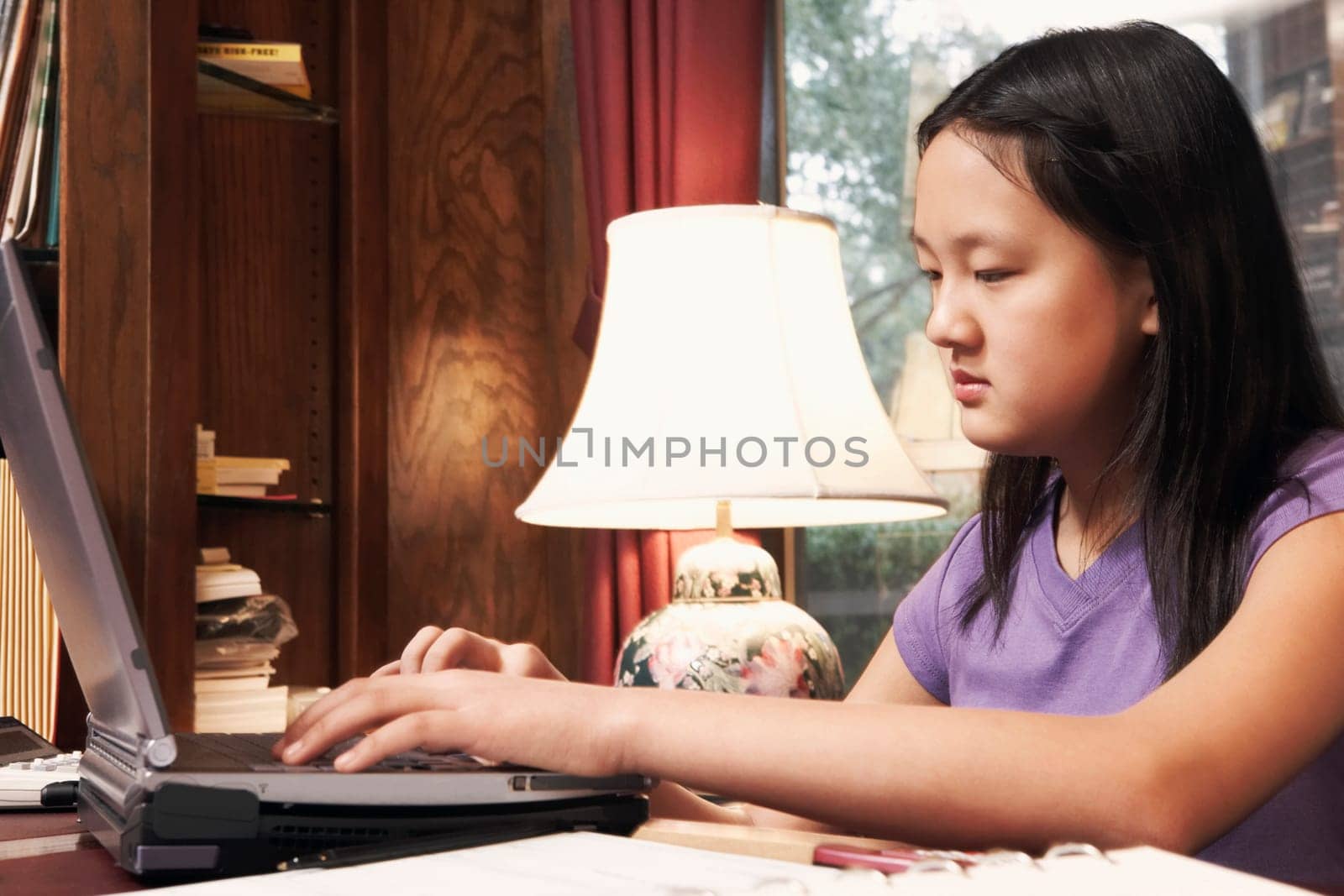 Side profile of a girl using a laptop