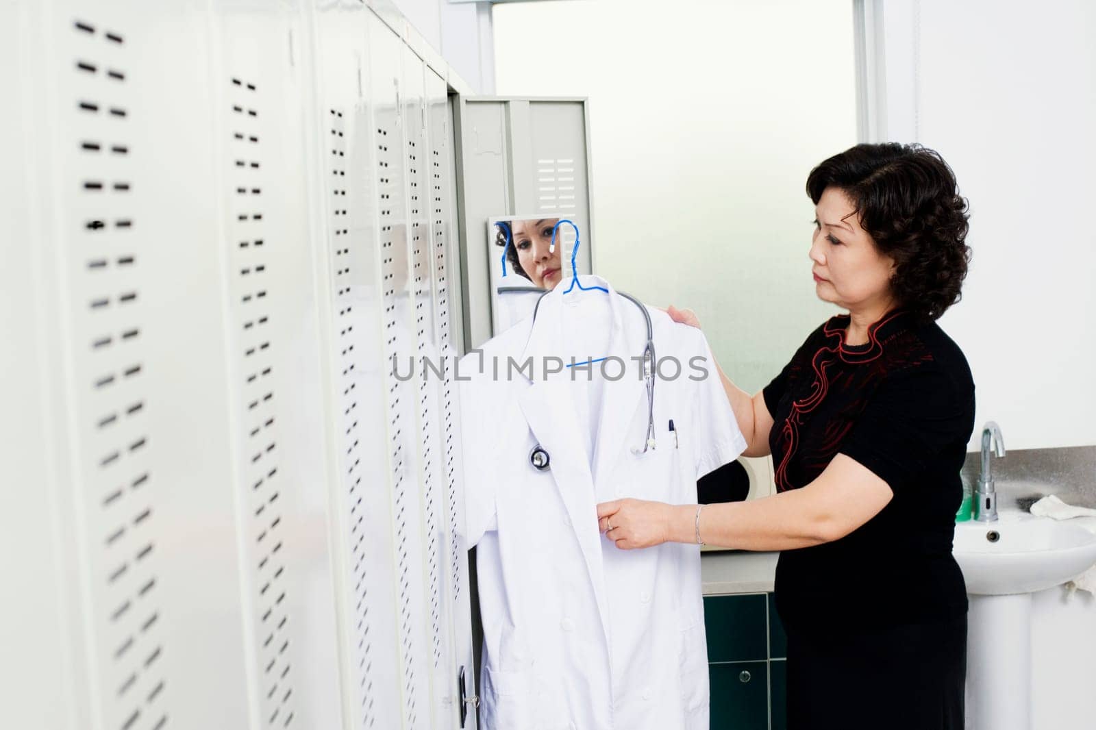 Side profile of a female doctor holding a lab coat