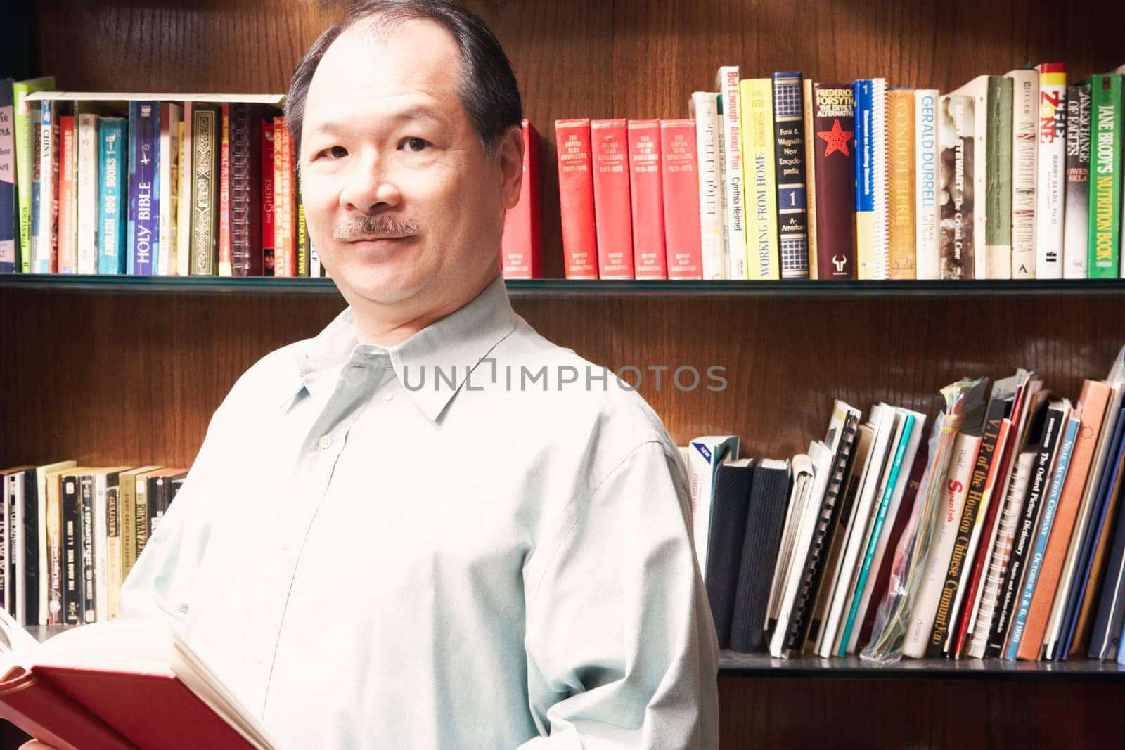 Portrait of a senior man holding a book