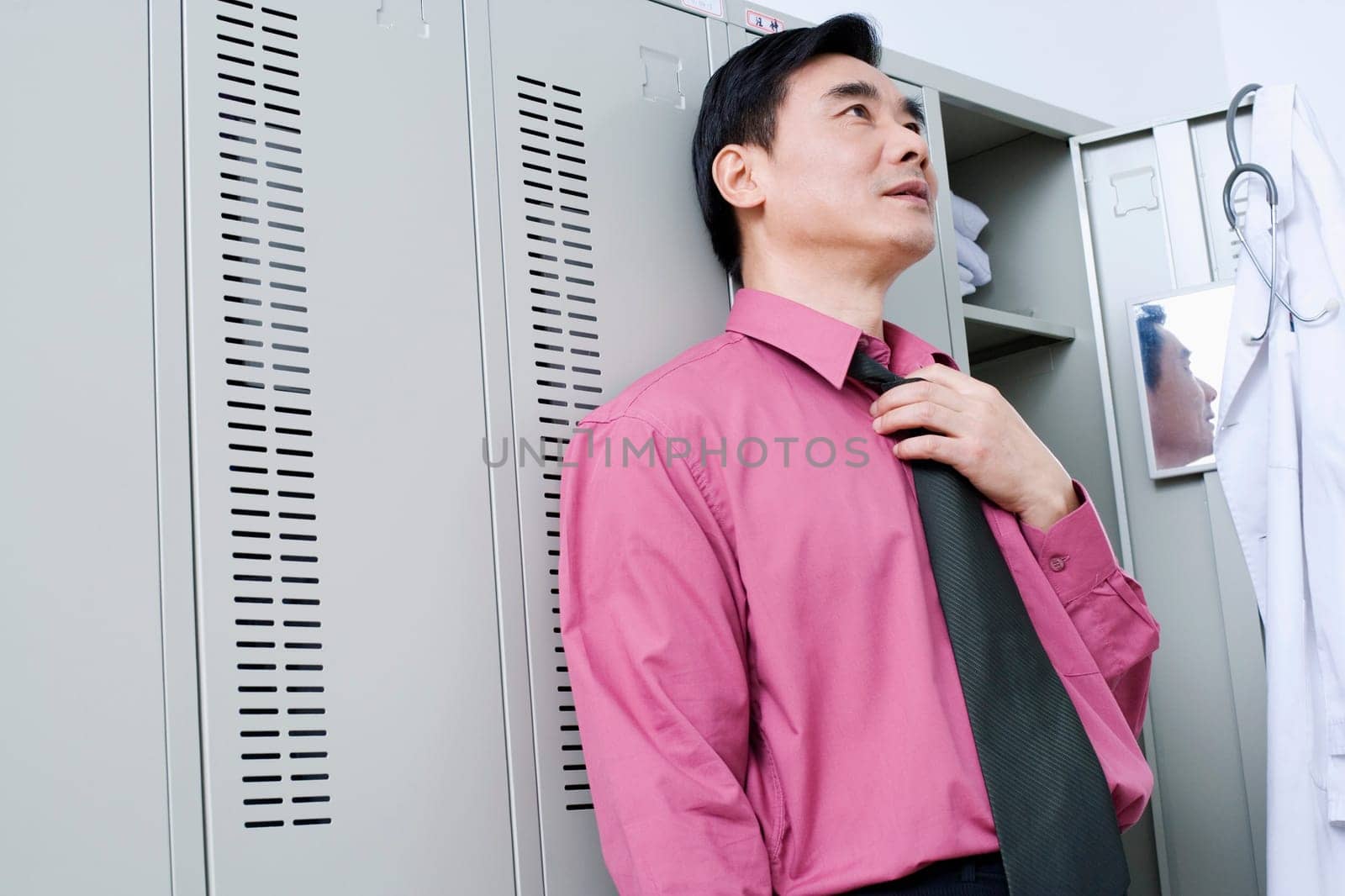 Close-up of a doctor leaning against a locker