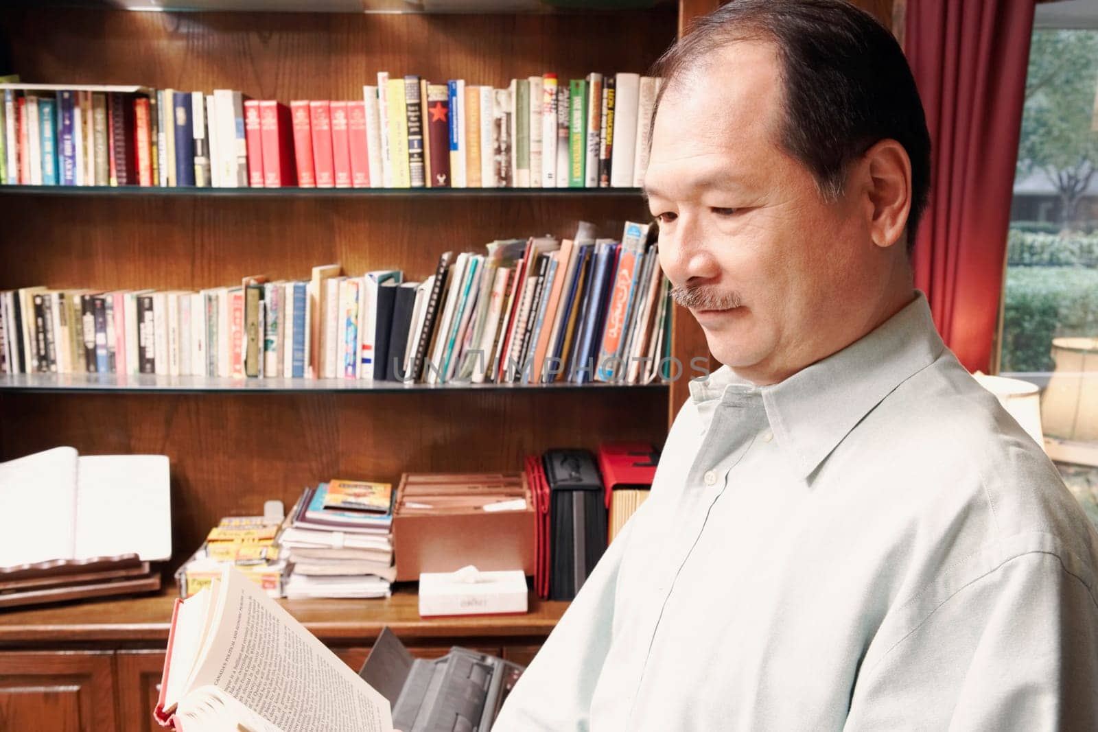 Side profile of a senior man reading a book